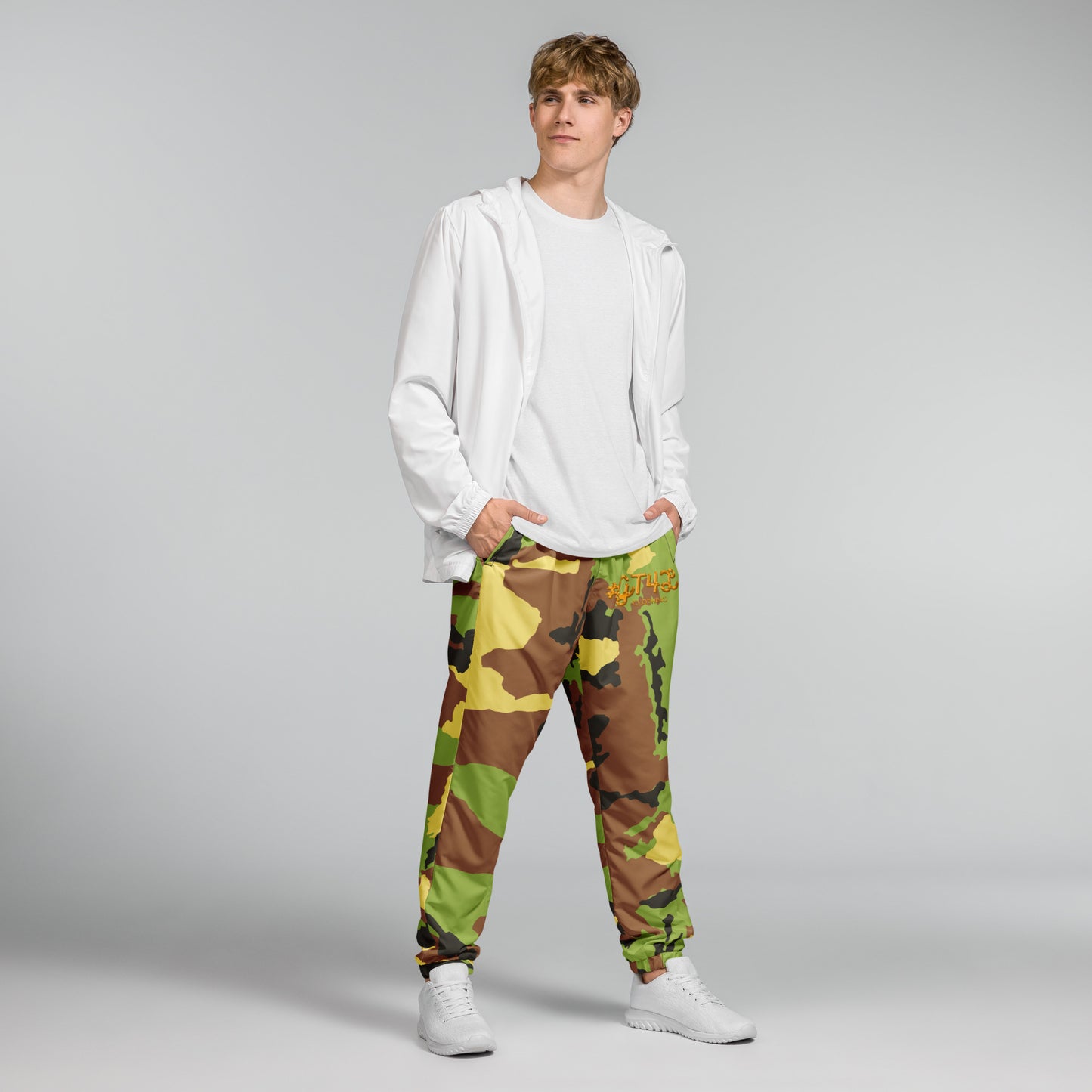 Person wearing a white hoodie and camouflage pants on a gray background