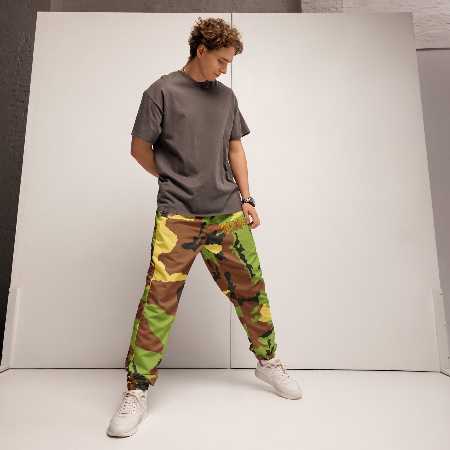 Person wearing a gray t-shirt and camouflage pants against a white background