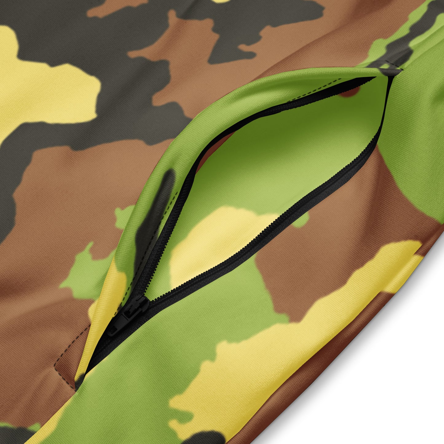 Close-up of a camouflage-patterned fabric with a green zipper.