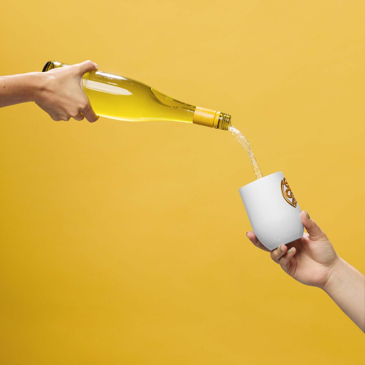 White wine being poured from a bottle into a white cup with a logo on a yellow background