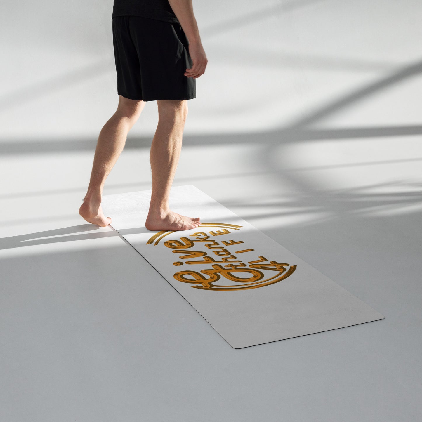 Person standing on a yoga mat with 'Live Life' text on a white floor