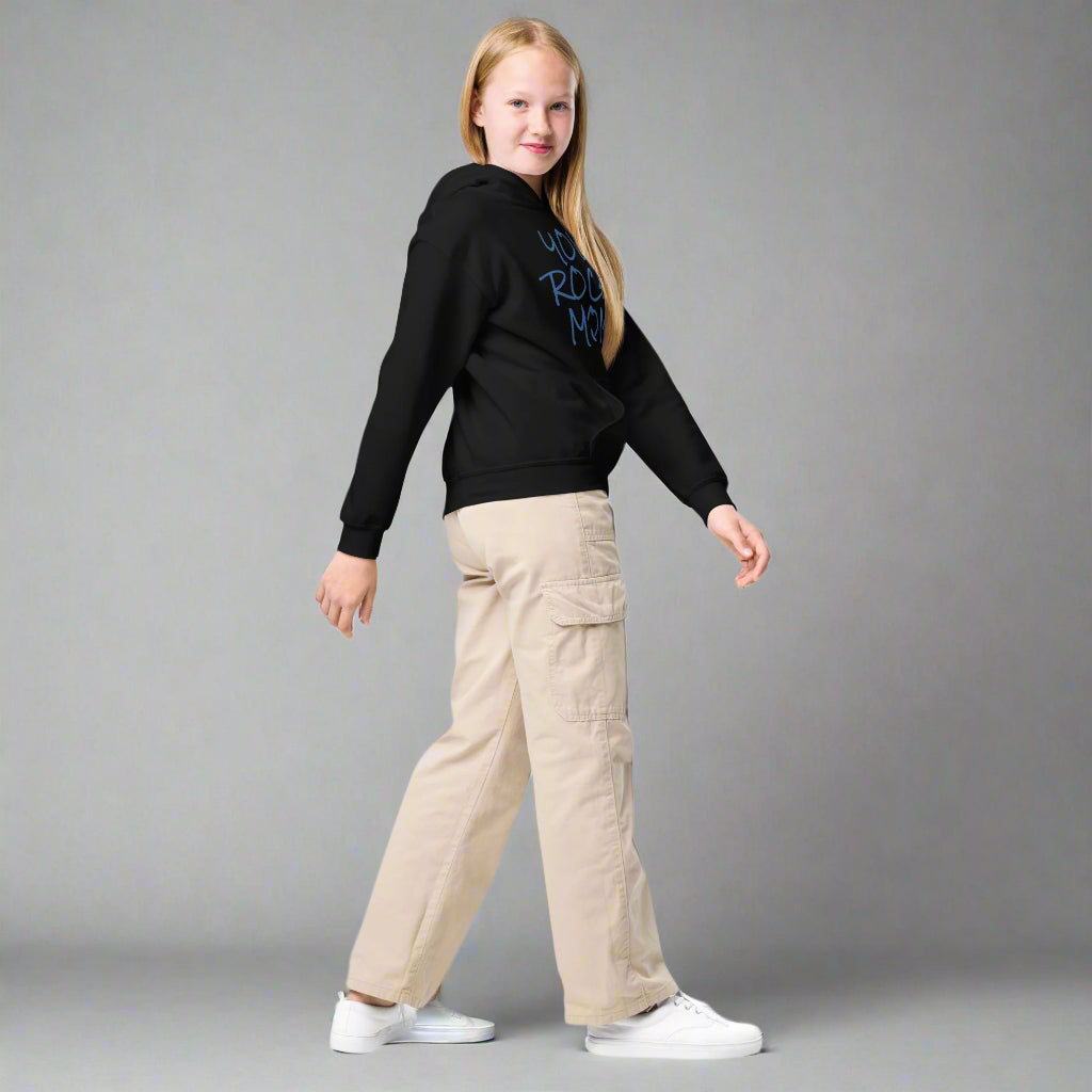 Person wearing a black hoodie with text and beige cargo pants on a white background
