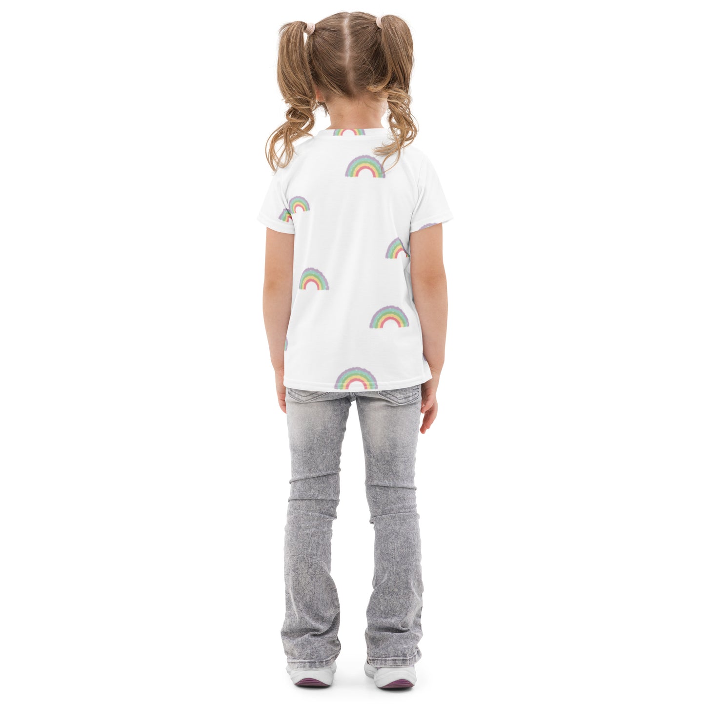 Child wearing a white t-shirt with rainbow patterns on a white background