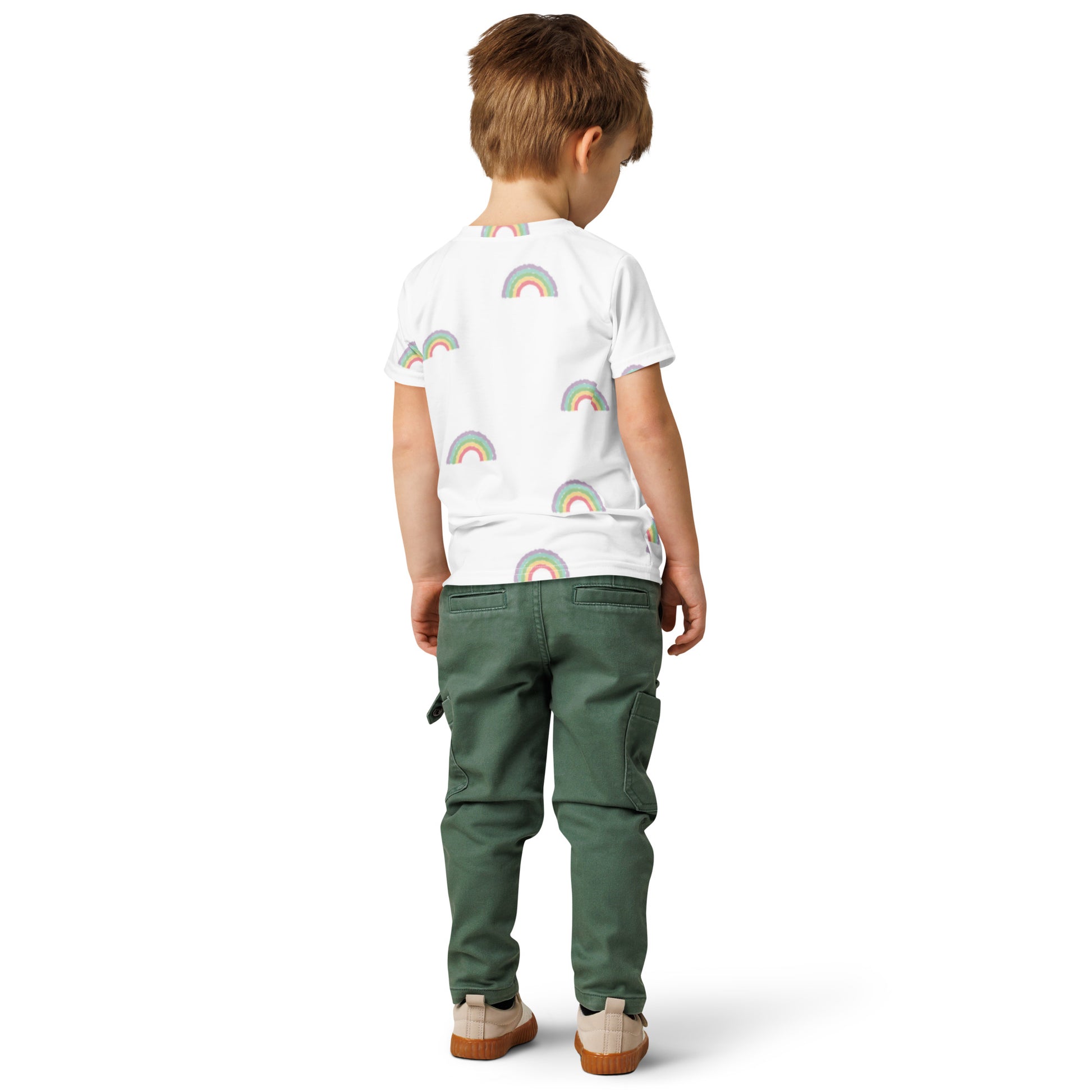 Child wearing a white t-shirt with rainbow patterns and green pants on a white background