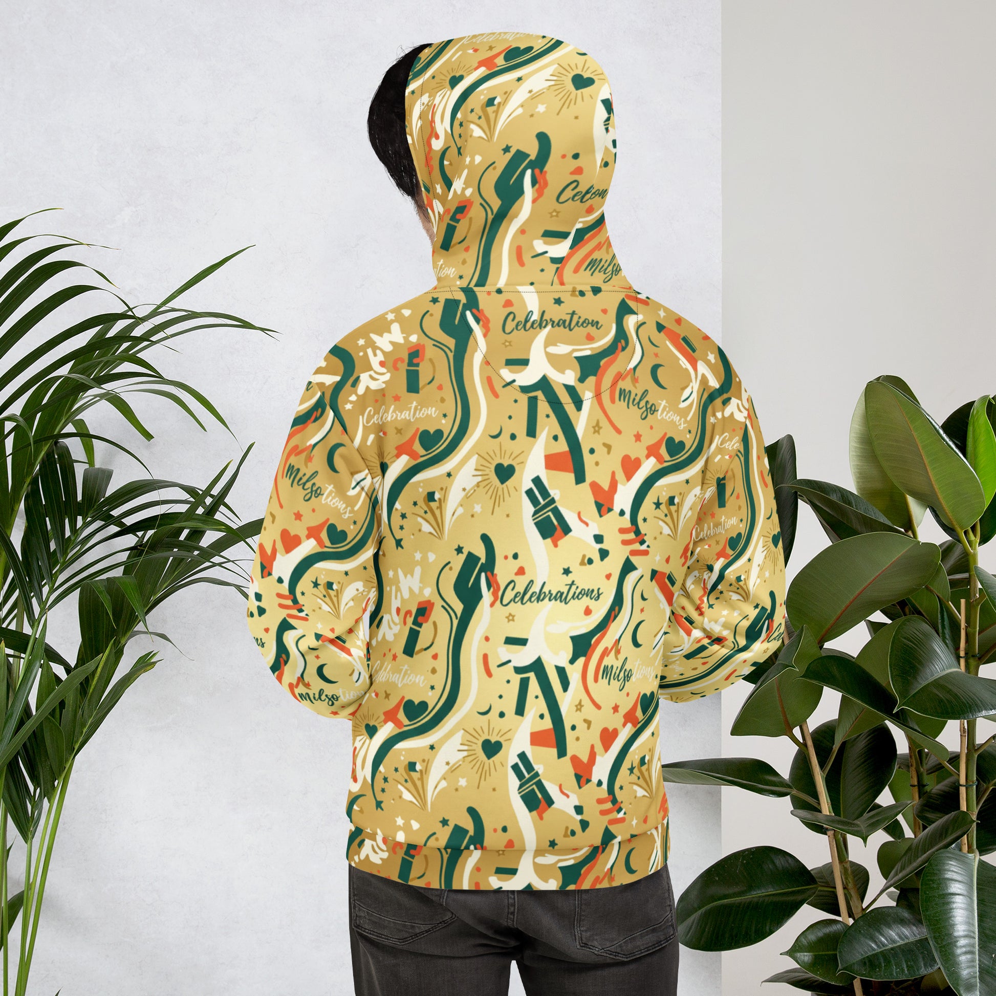Person wearing a colorful hoodie with abstract design in front of plants