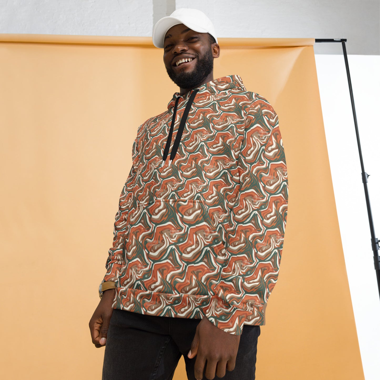 Man wearing a patterned hoodie against an orange background