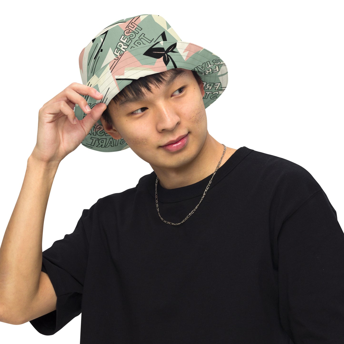Person wearing a patterned bucket hat and black shirt on a white background
