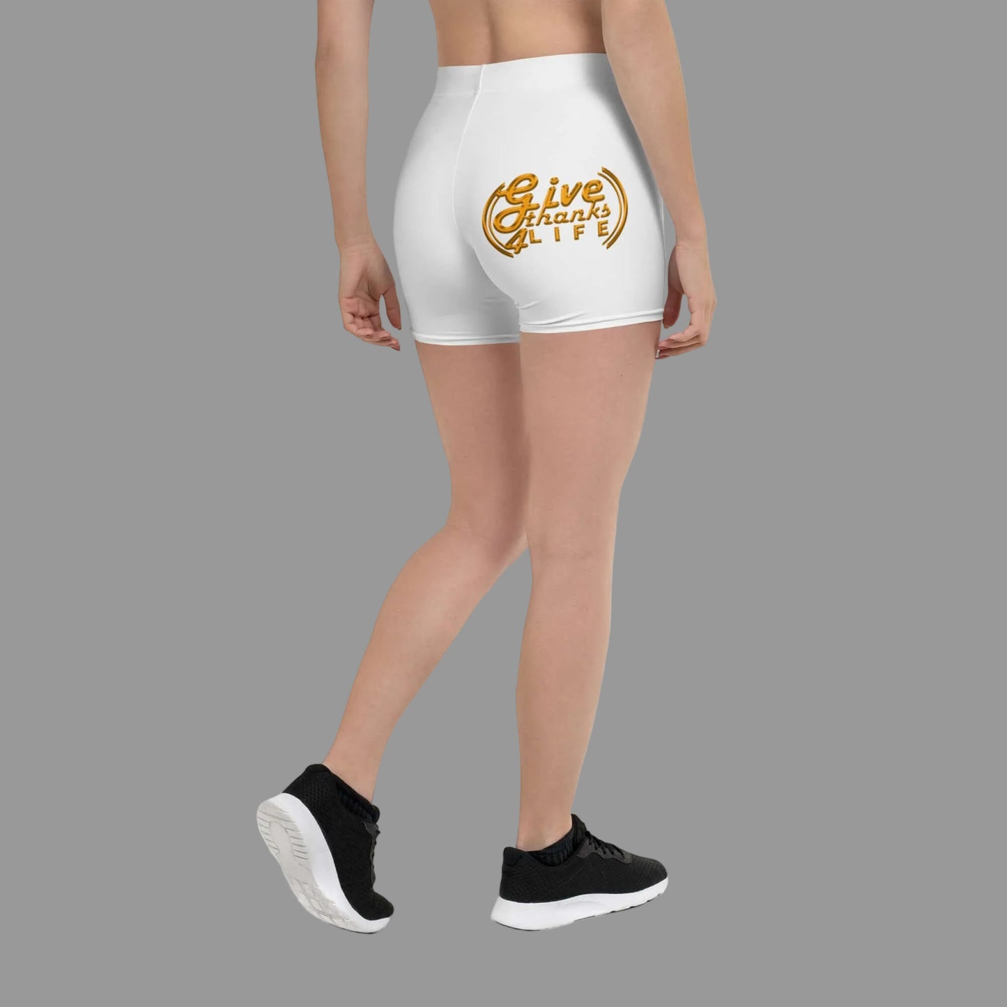 White shorts with 'Give Thanks' design worn by a person on a white background