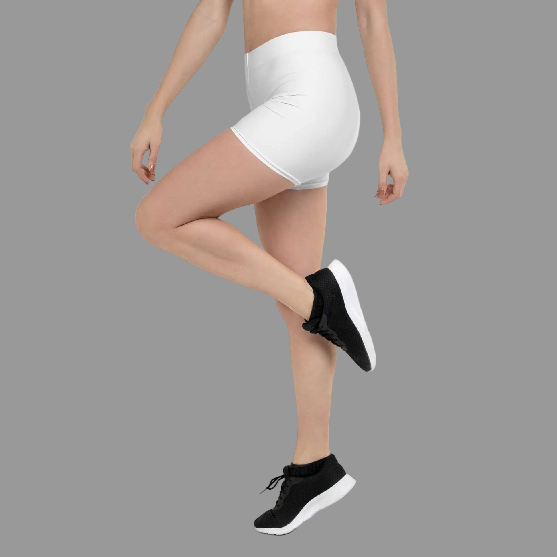 Person wearing white athletic shorts and black athletic shoes on a white background