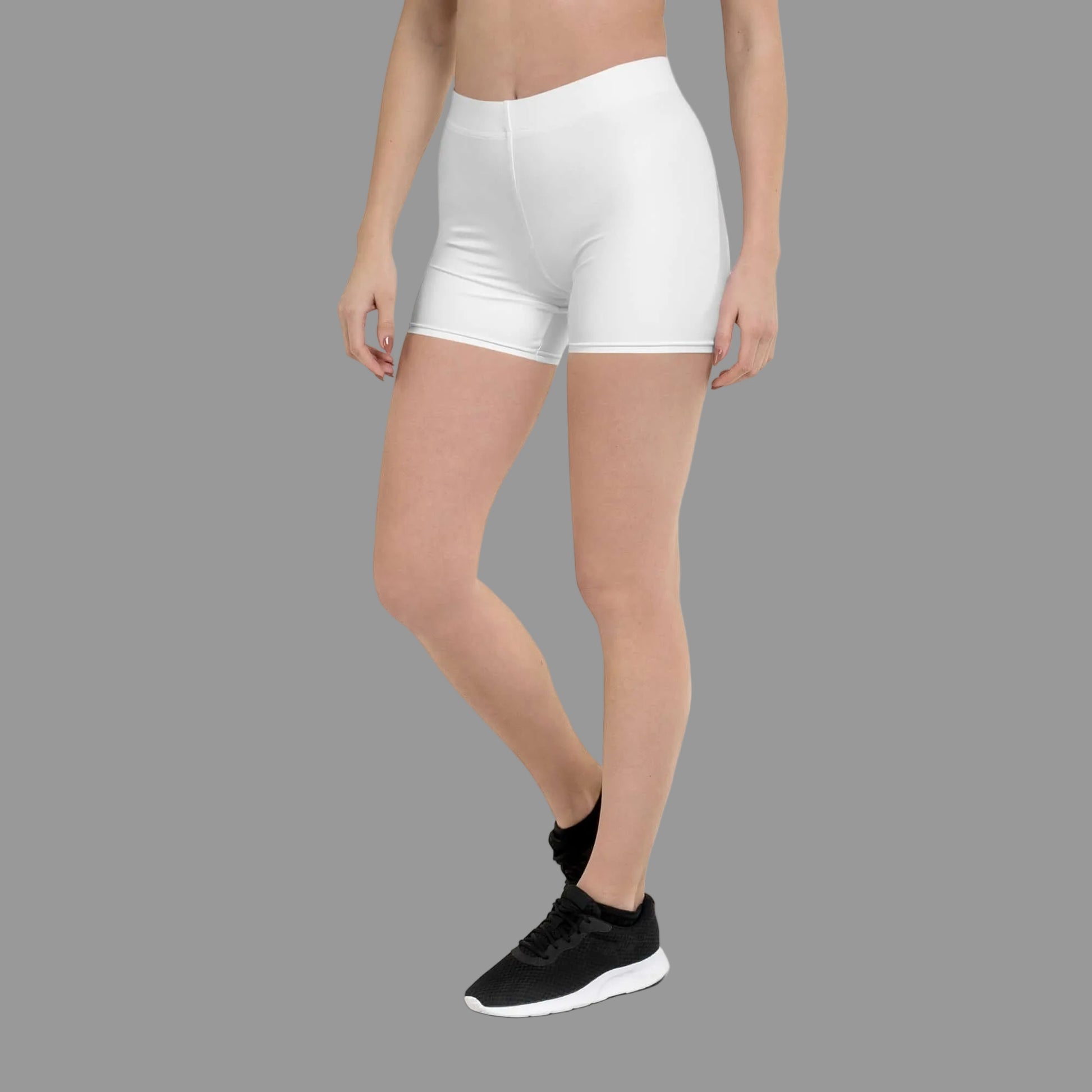 Person wearing white athletic shorts and black sneakers on a white background