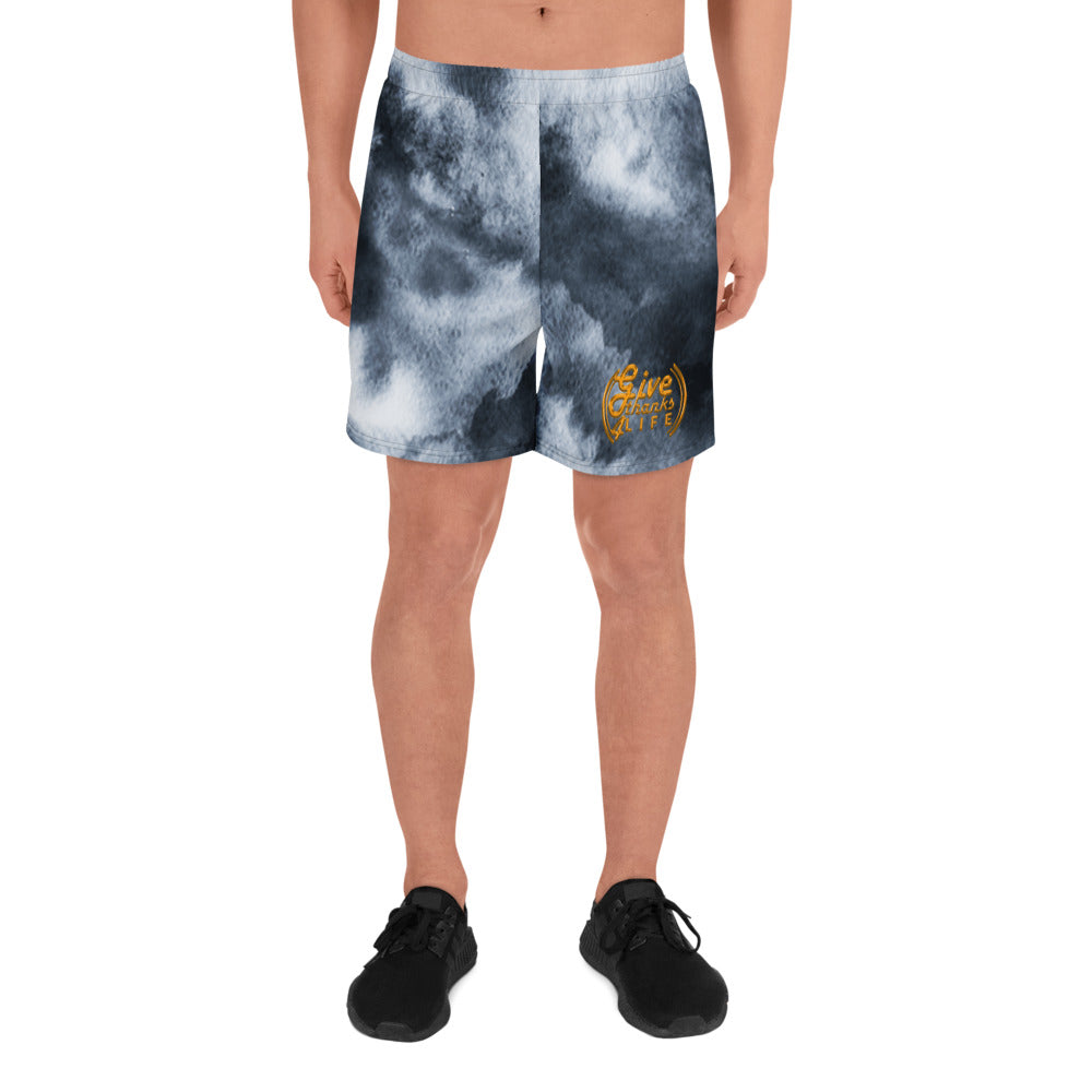 Person wearing tie-dye shorts with a logo on a white background