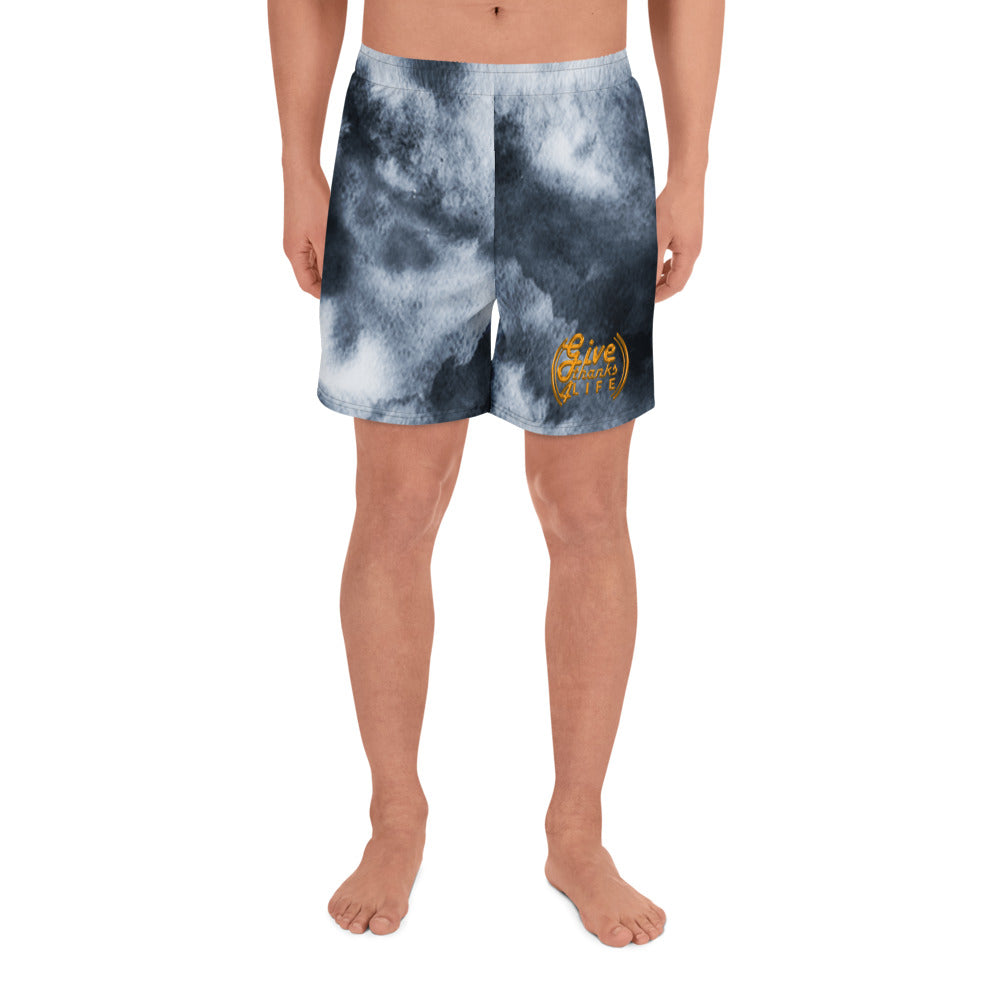 Person wearing tie-dye shorts with a logo on a white background