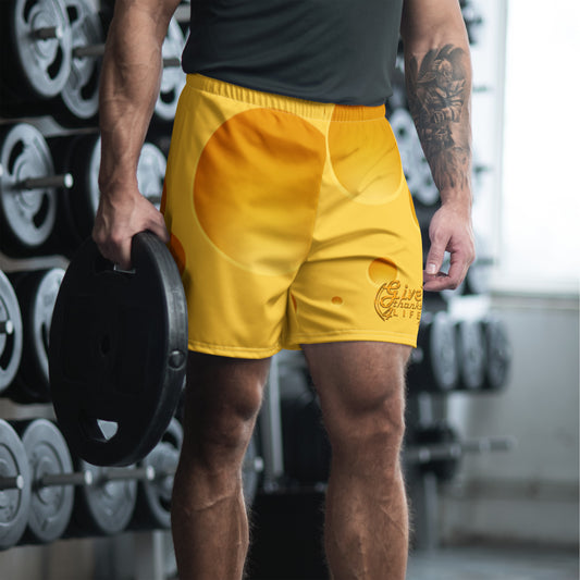 Person wearing yellow shorts with a brand logo in a gym setting