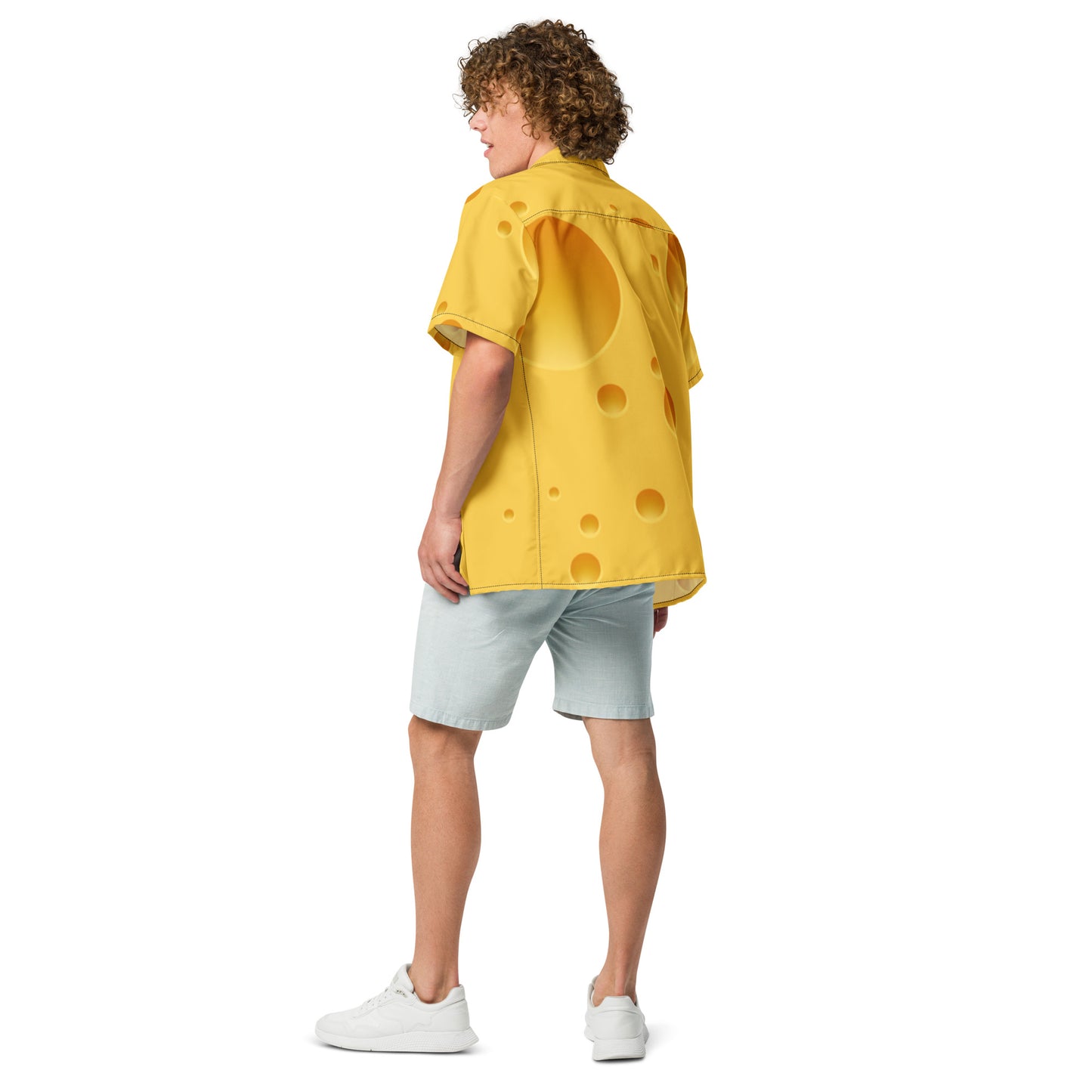 Person wearing a yellow shirt with a polka dot pattern on a white background