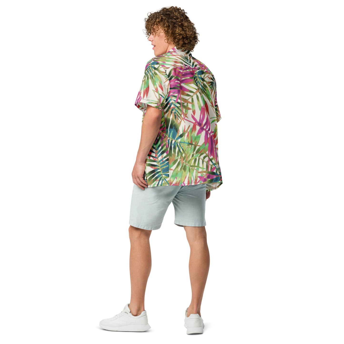 Person wearing a colorful tropical shirt and light shorts on a white background