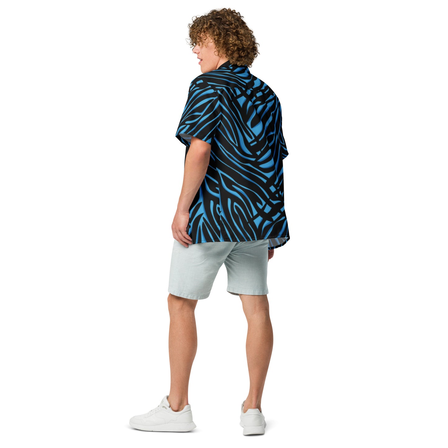 Person wearing a blue and black patterned shirt and light gray shorts on a white background