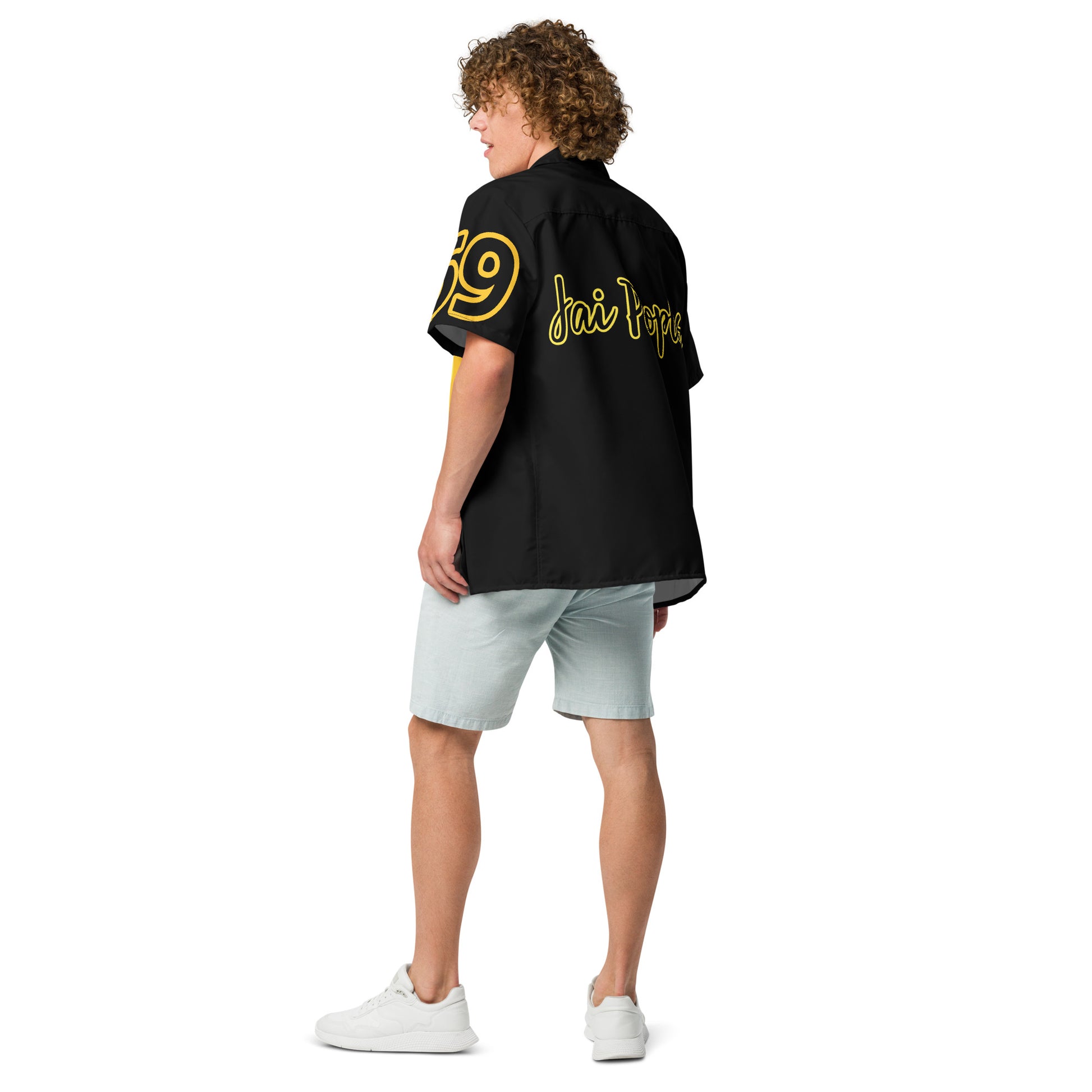 Person wearing a black shirt with yellow text and light blue shorts on a white background