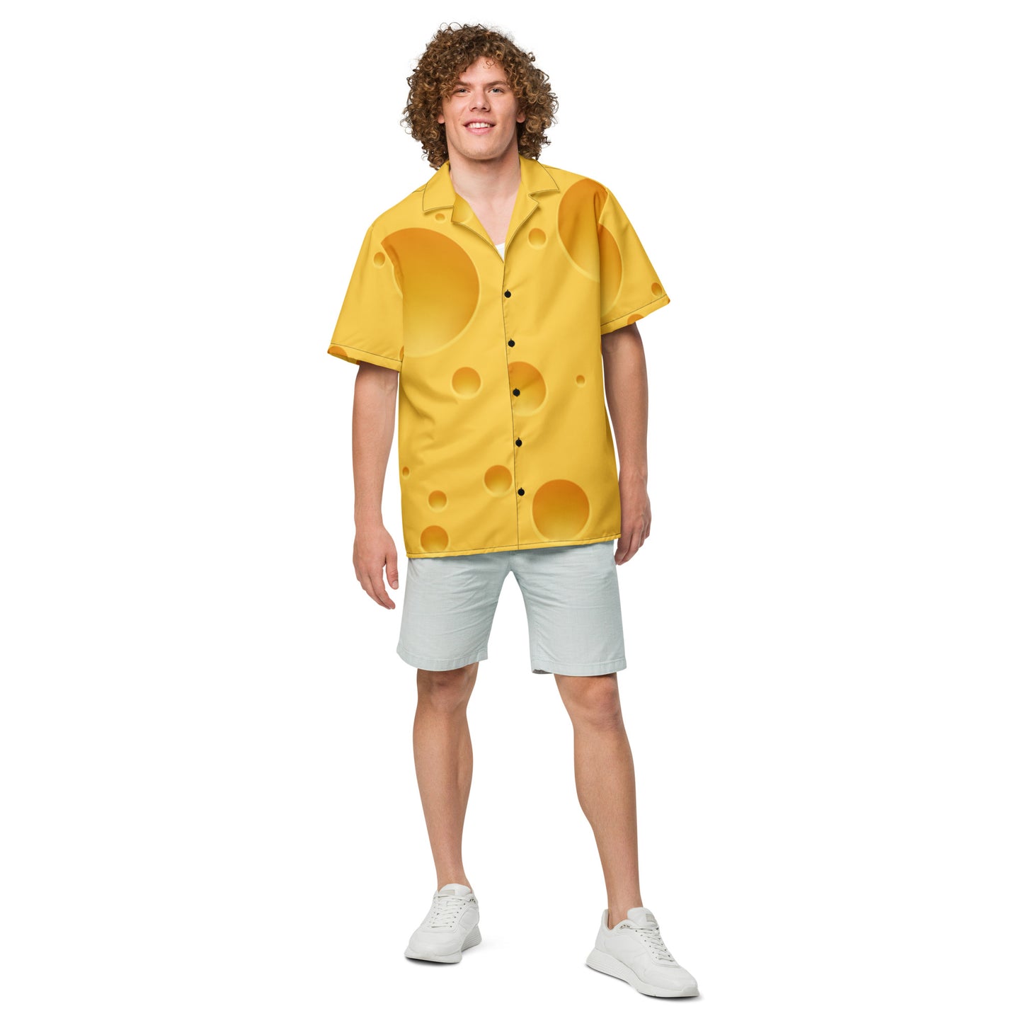 Person wearing a yellow shirt with circular patterns and light gray shorts on a white background
