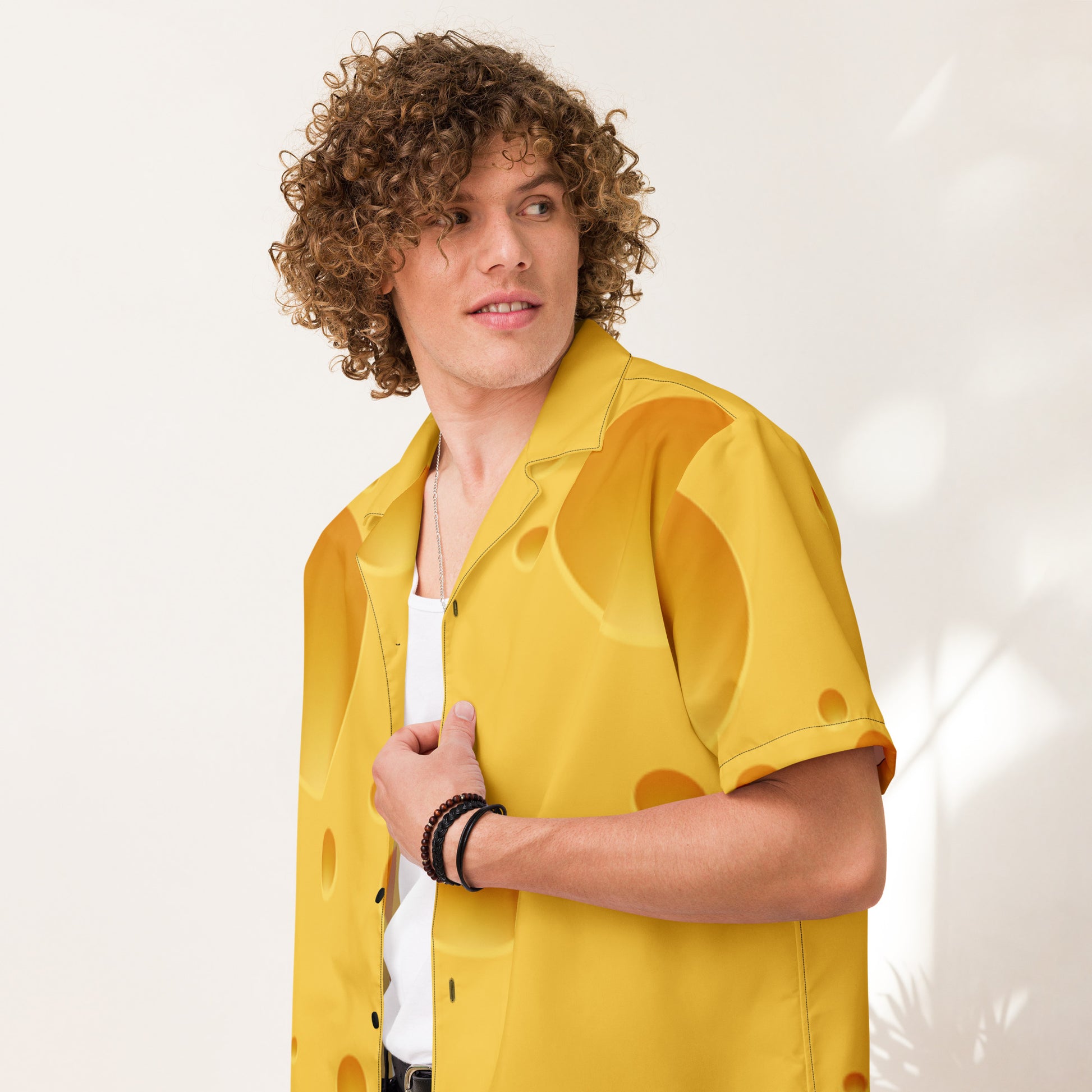 Person wearing a yellow shirt with a visible brand logo on a white background