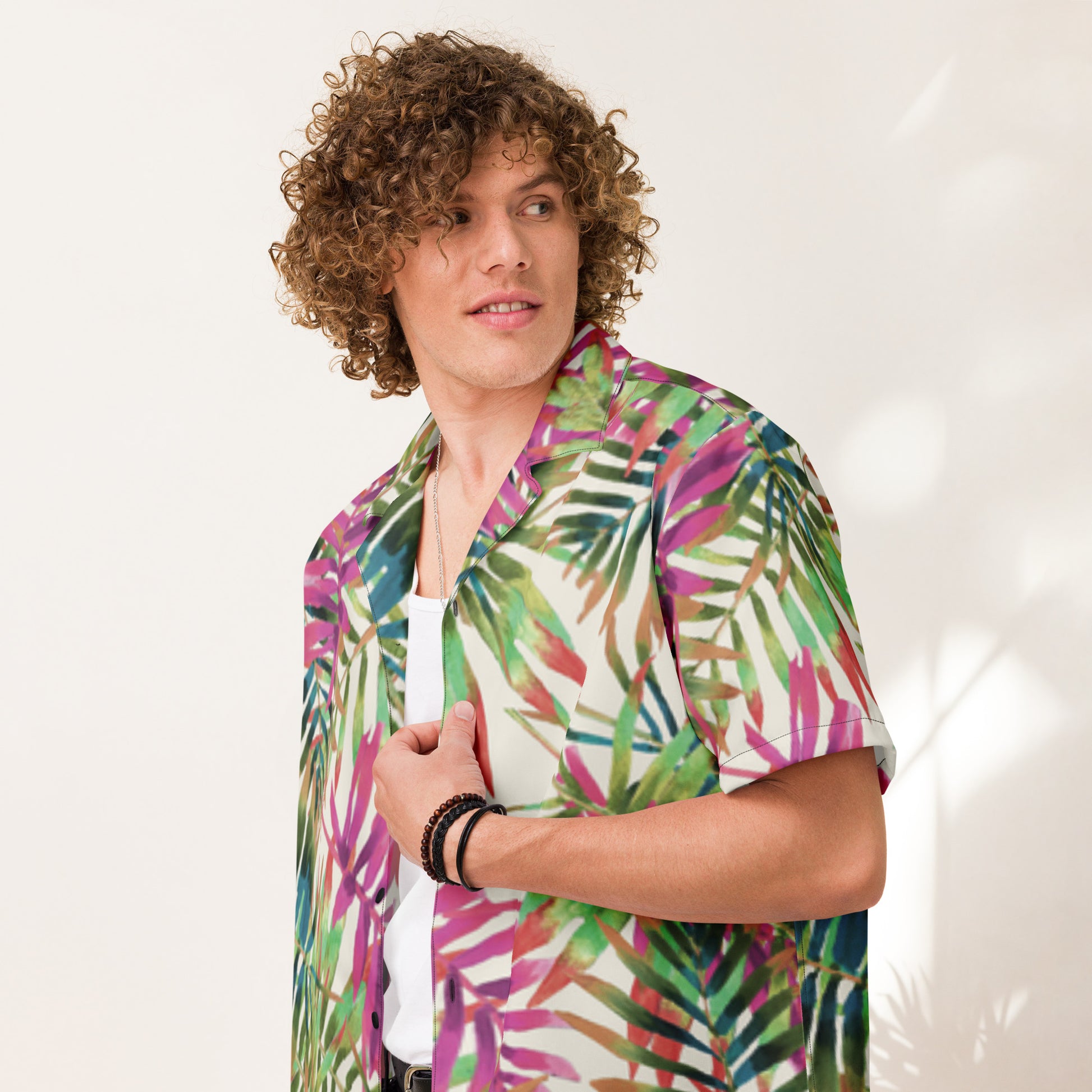 Person wearing a colorful tropical leaf patterned shirt against a white background