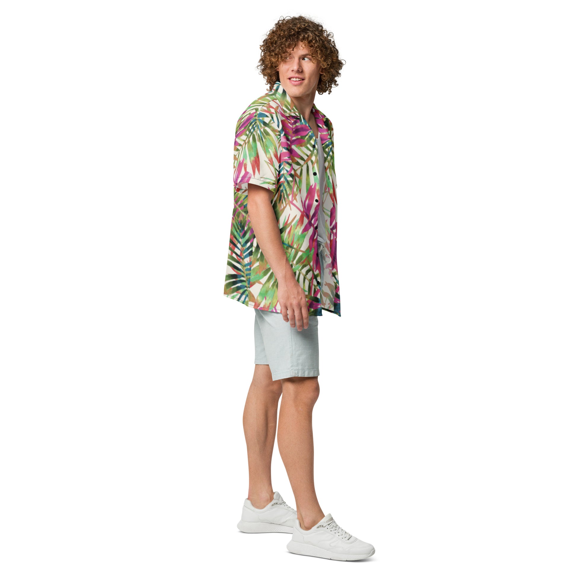Man wearing a colorful tropical shirt and light shorts on a white background