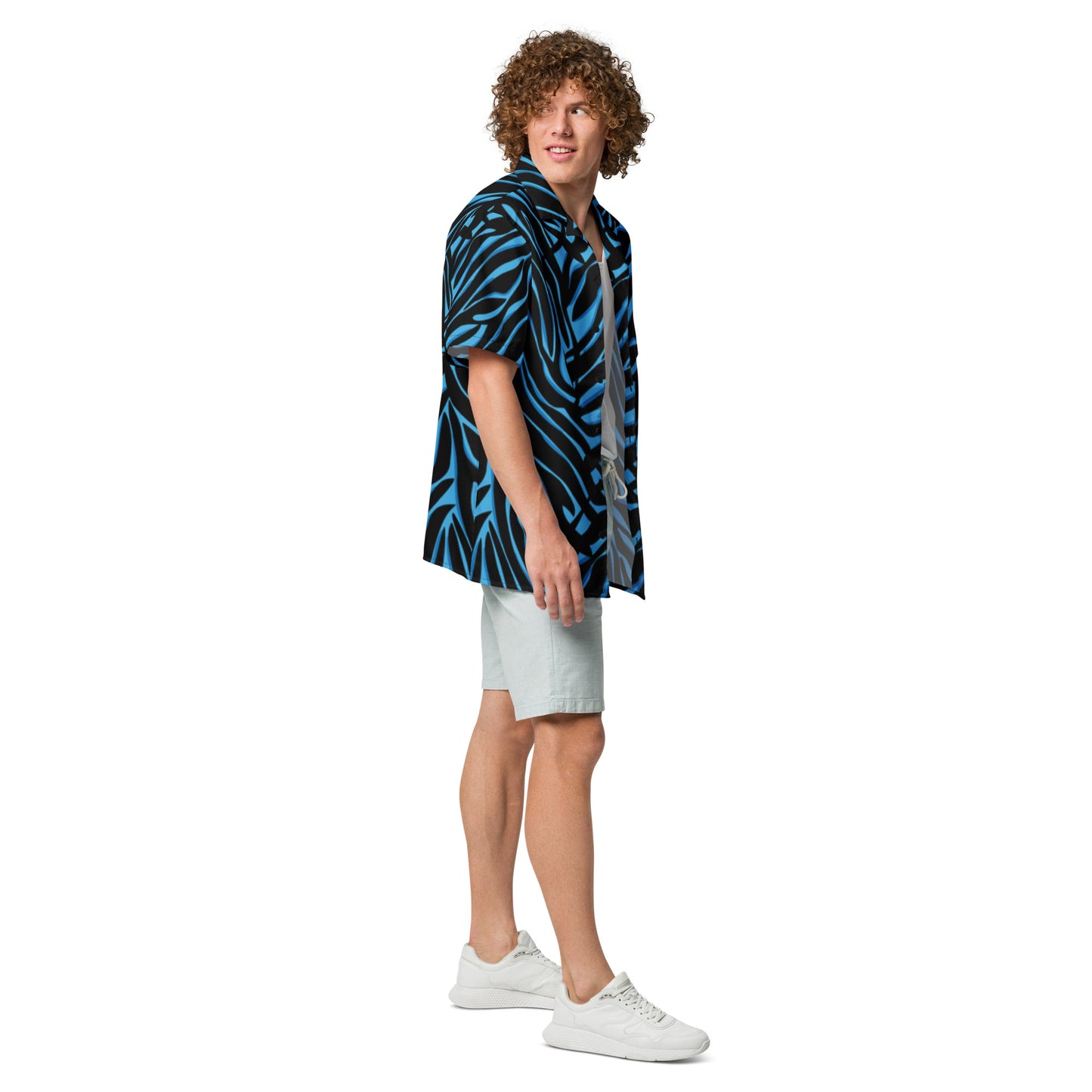 Man wearing a blue and black patterned shirt with white shorts on a white background