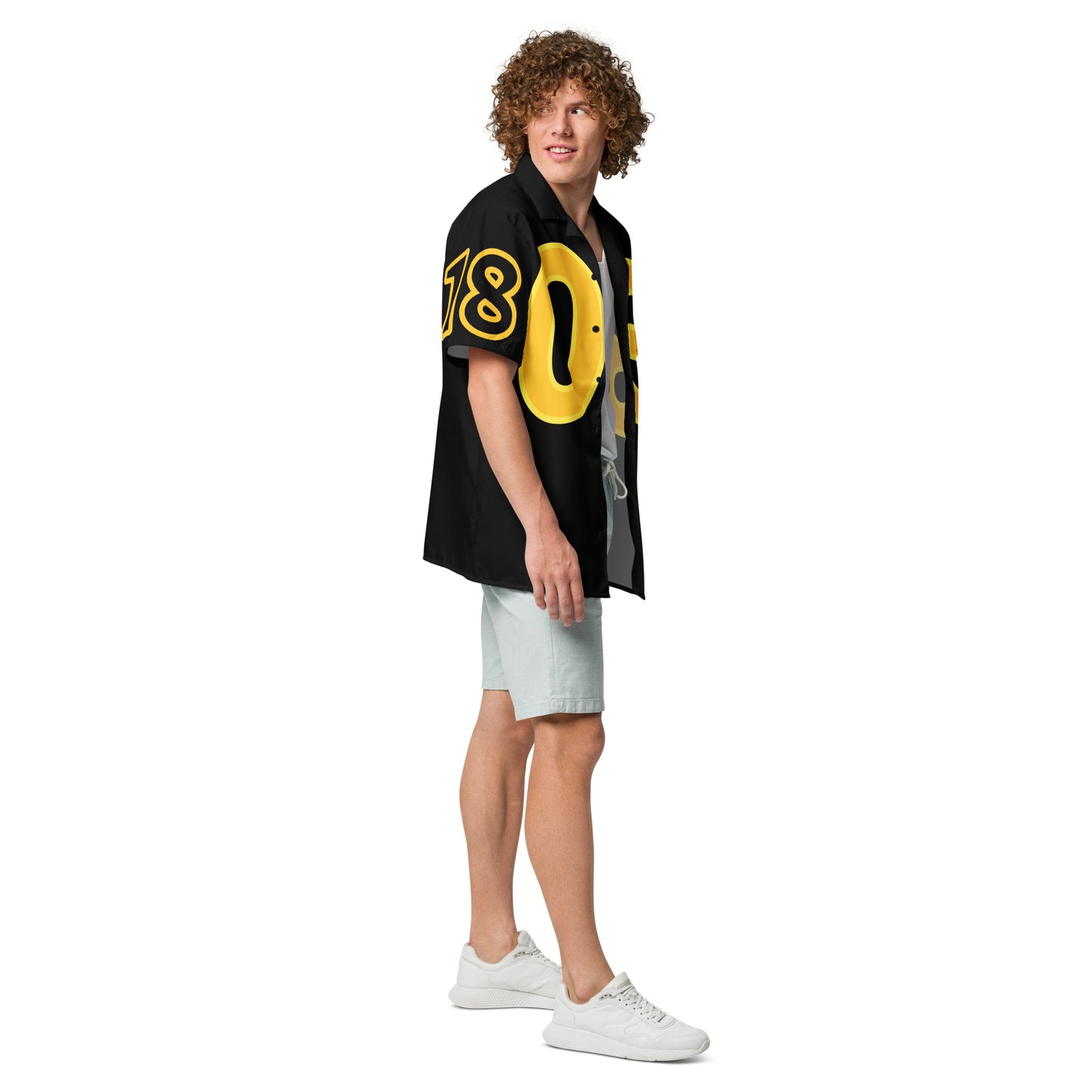 Person wearing a black shirt with yellow numbers and white shorts on a white background