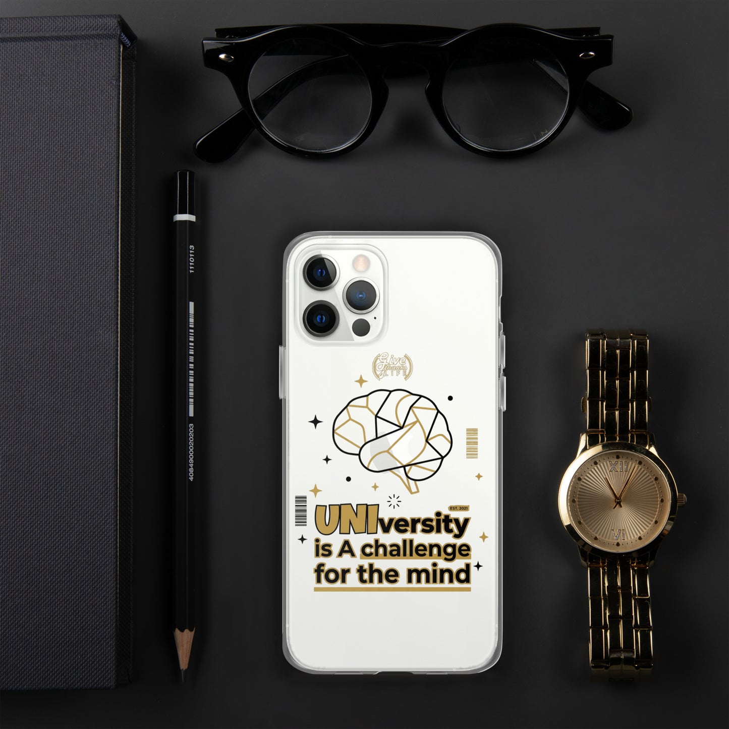 Phone case with 'UNI'versity is a challenge for the mind design on a dark surface with glasses, pen, and watch.