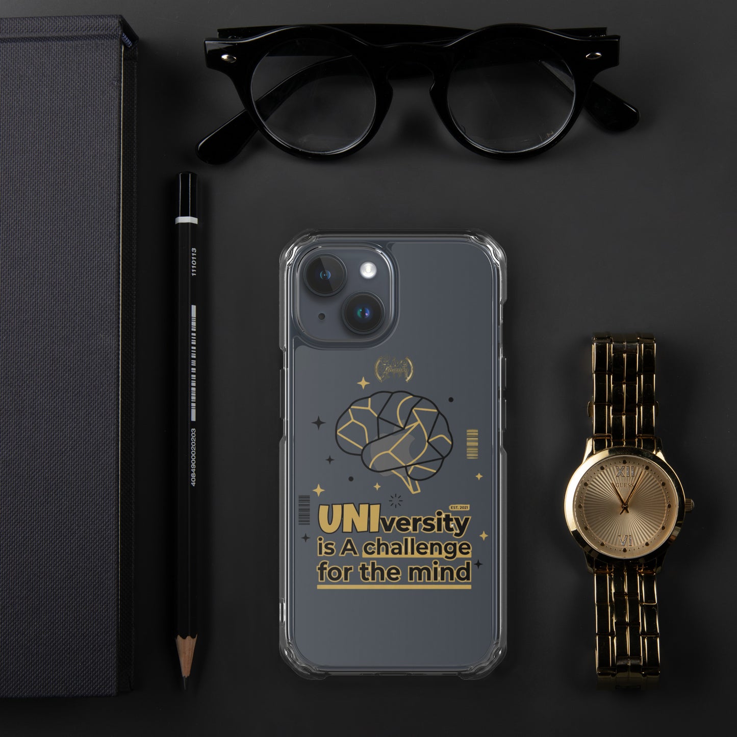 Phone case with motivational quote on a dark surface with glasses, pen, and watch.