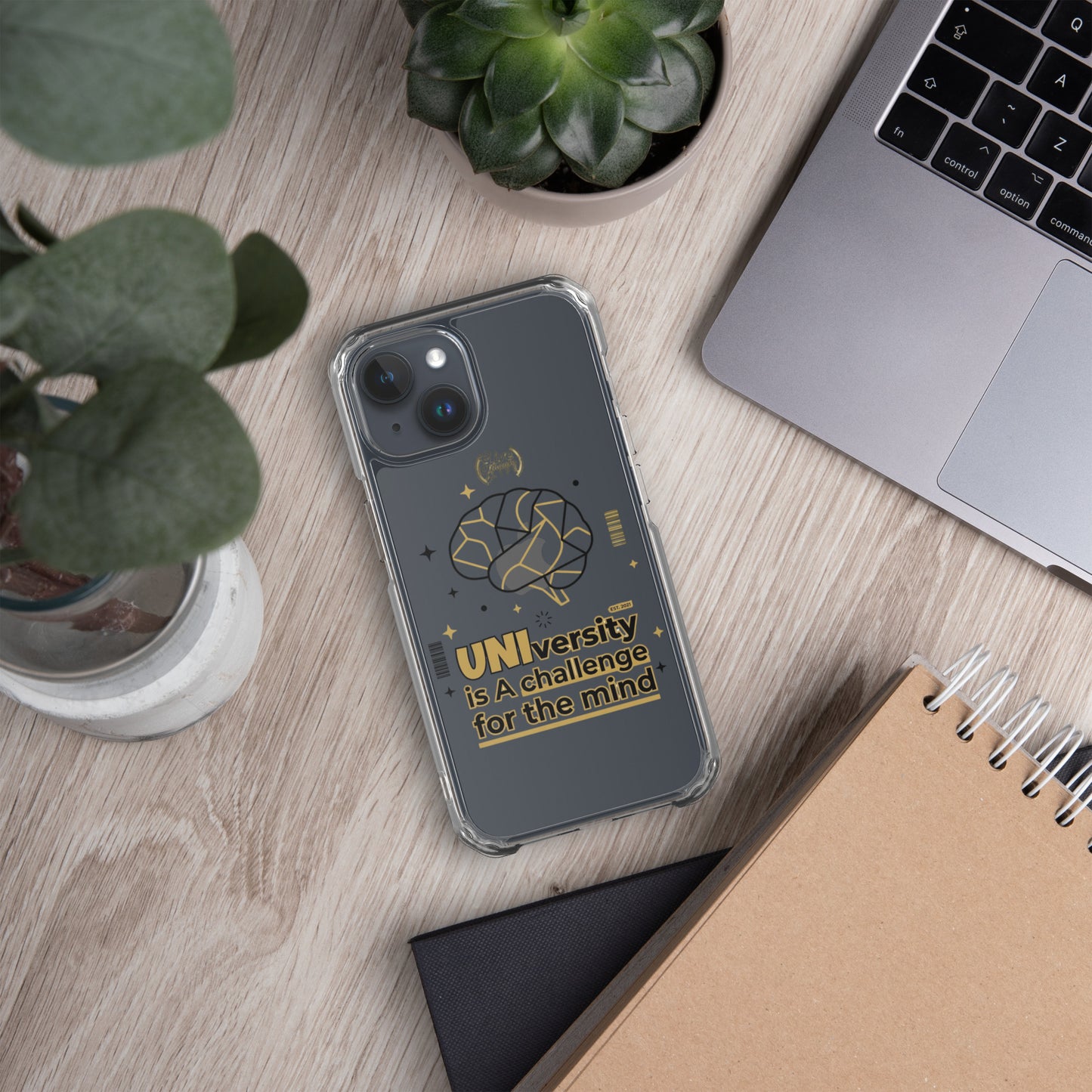 Phone case with motivational quote on a desk with laptop and plants