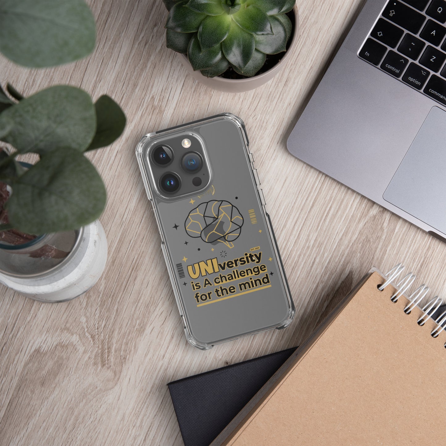 Phone case with colorful pattern on a wooden desk with laptop and plants