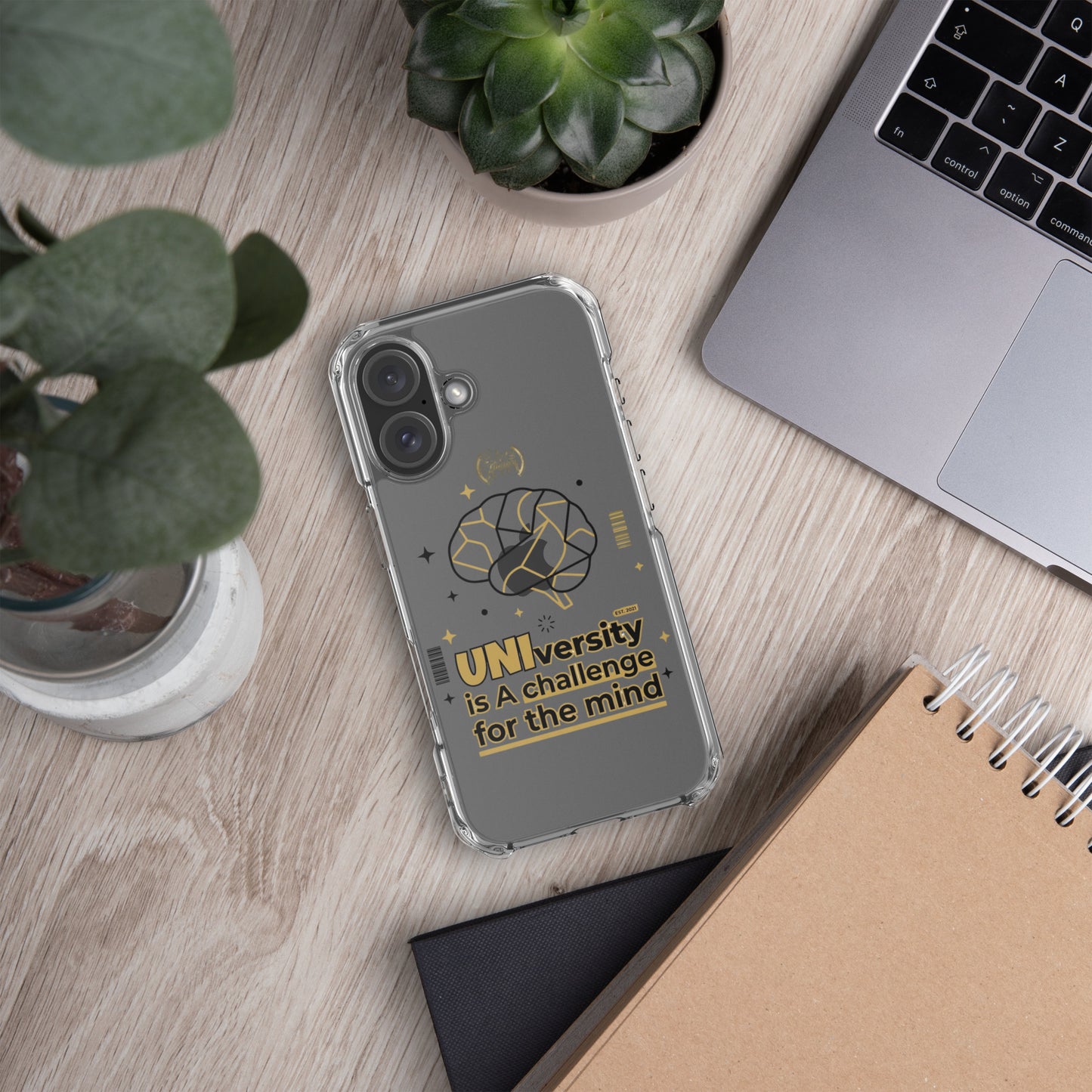 Phone case with colorful pattern on a wooden desk with laptop and plants