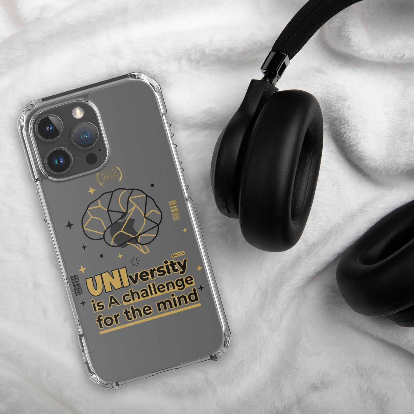 Phone case with 'UNIversity is a challenge for the mind' text and design, next to headphones on a textured surface.