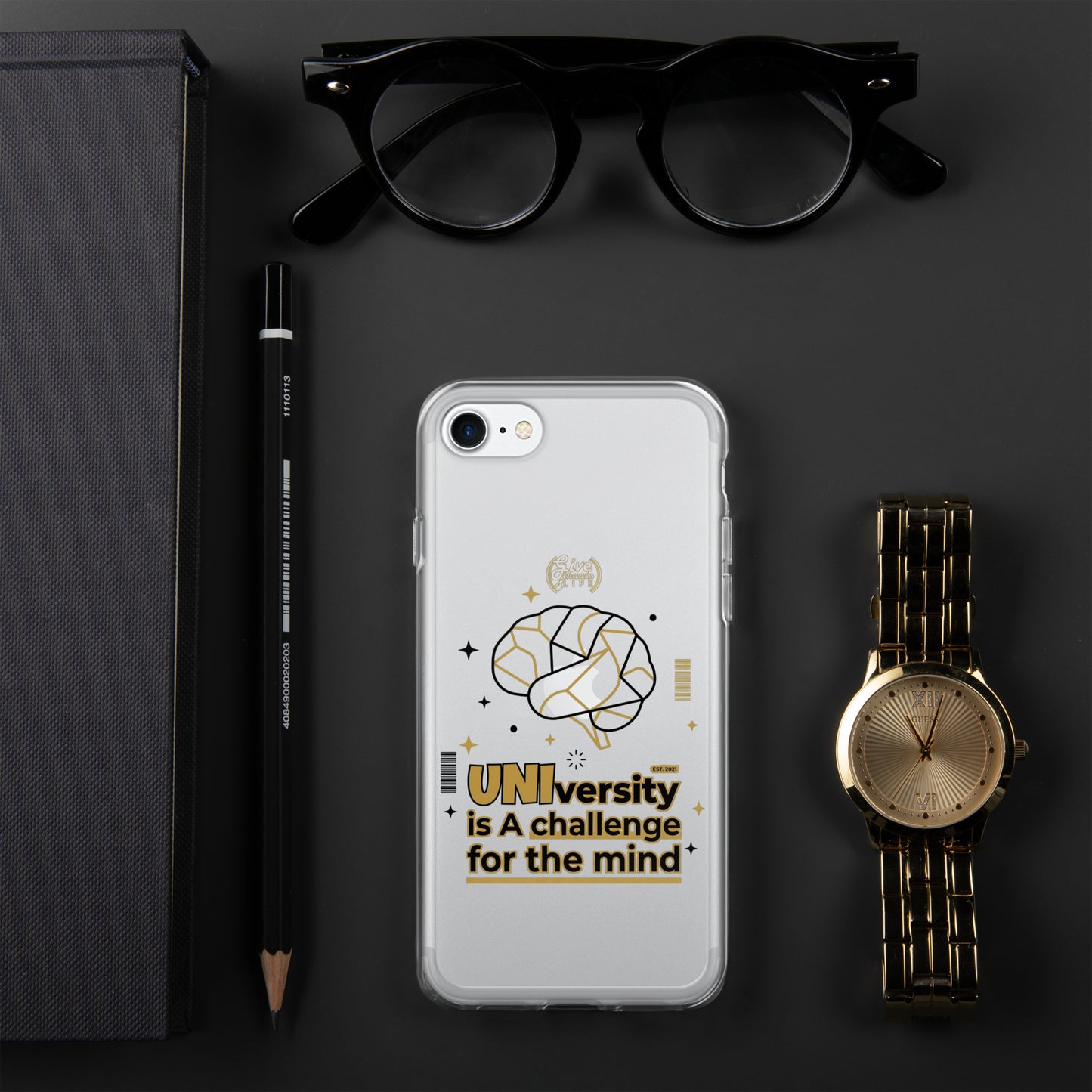Phone case with brain design and text, placed on a dark surface with glasses, pen, and watch.
