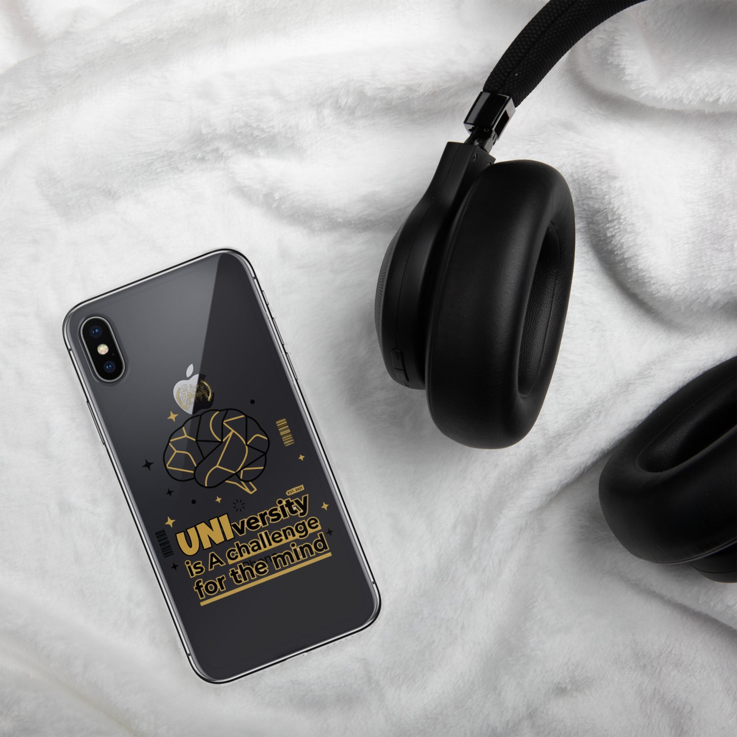 Black smartphone with Apple logo and black headphones on a white fabric background