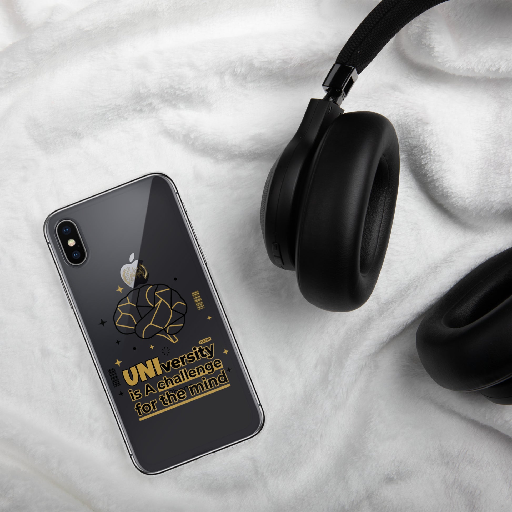 Black smartphone with Apple logo and black headphones on a white fabric background