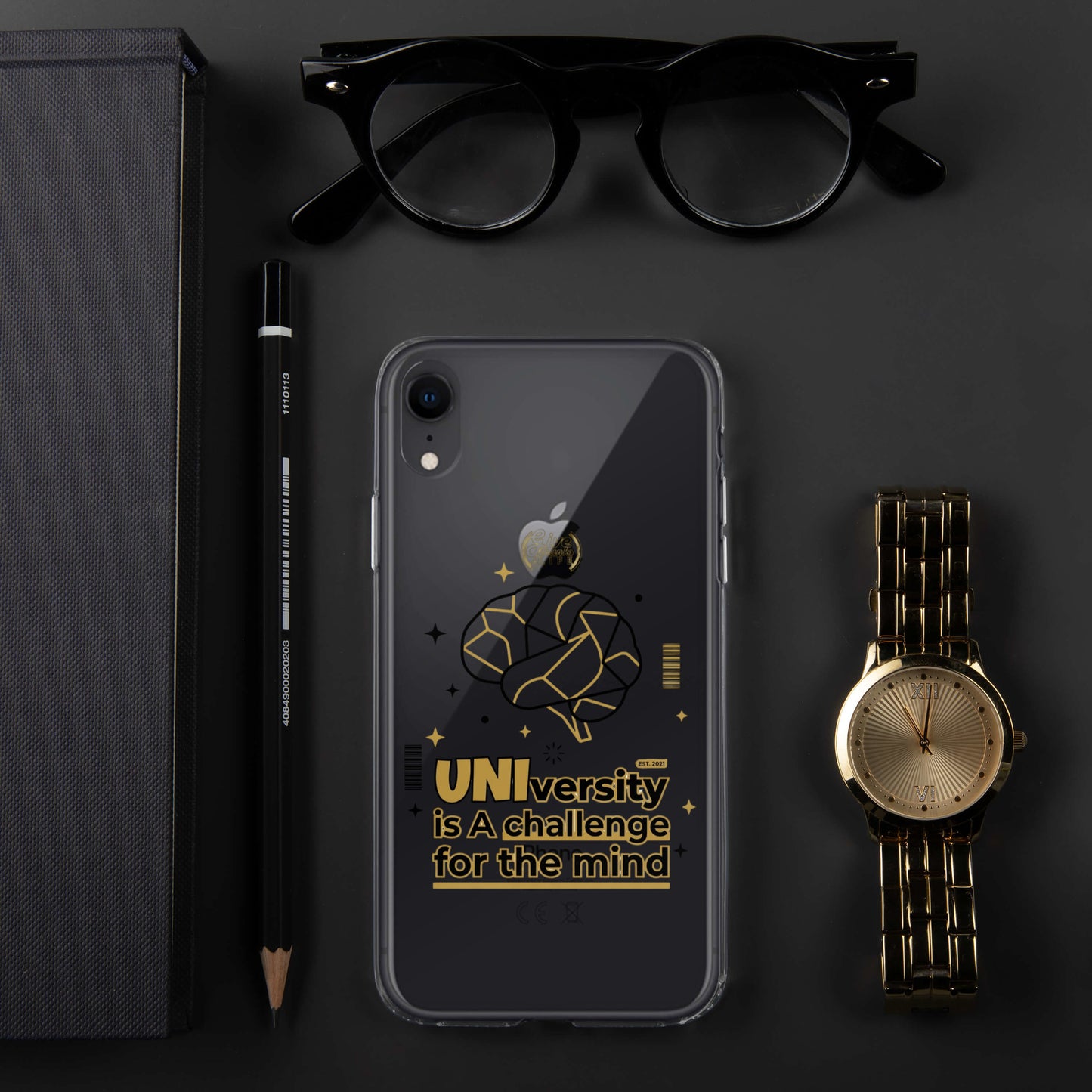Phone case with text, glasses, pen, pencil, notebook, and watch on a dark surface