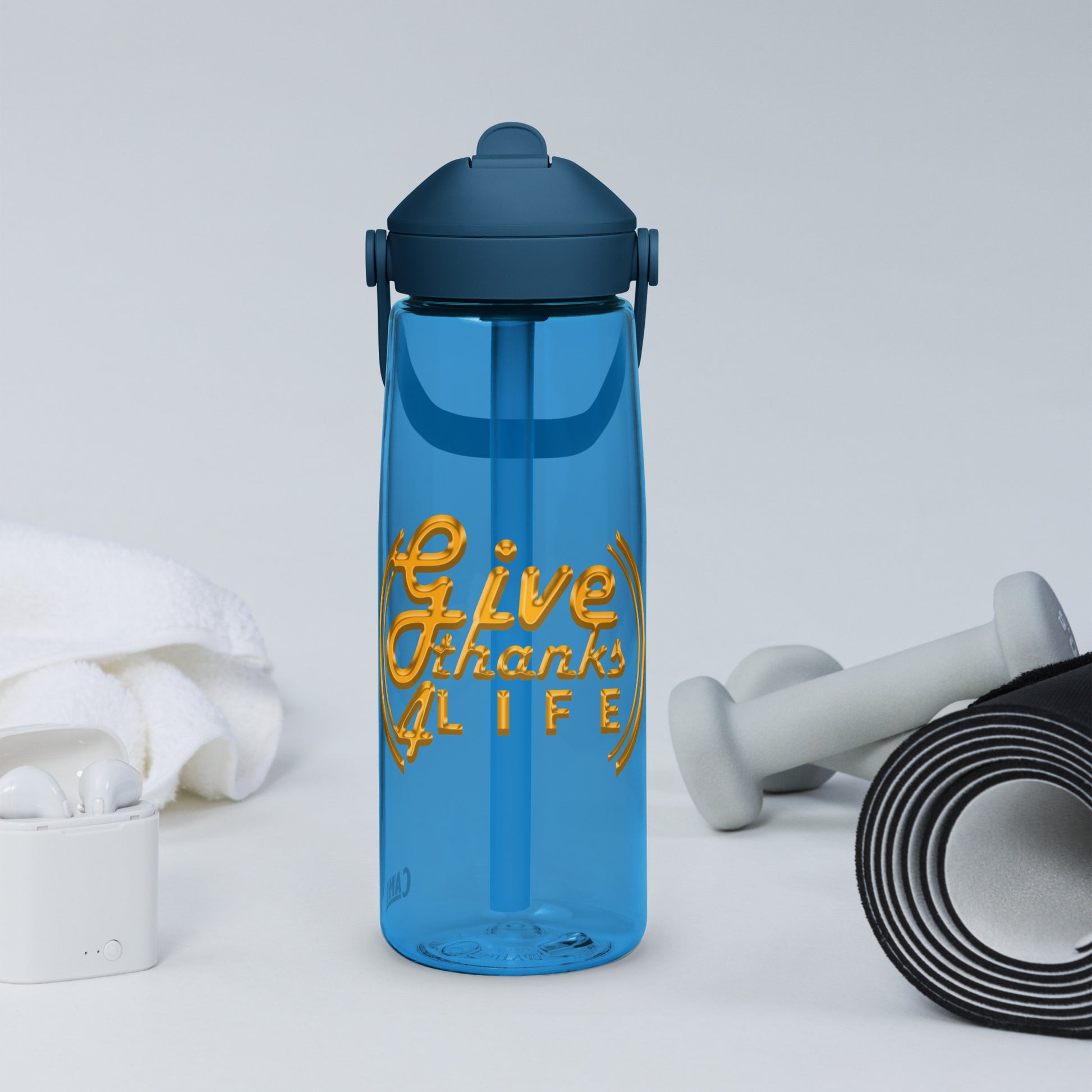 Blue water bottle with 'Give Thanks for Life' text, dumbbells, and earbuds on a light gray background
