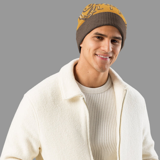 Man wearing a white jacket, beige sweater, and brown beanie with a yellow pattern on a white background
