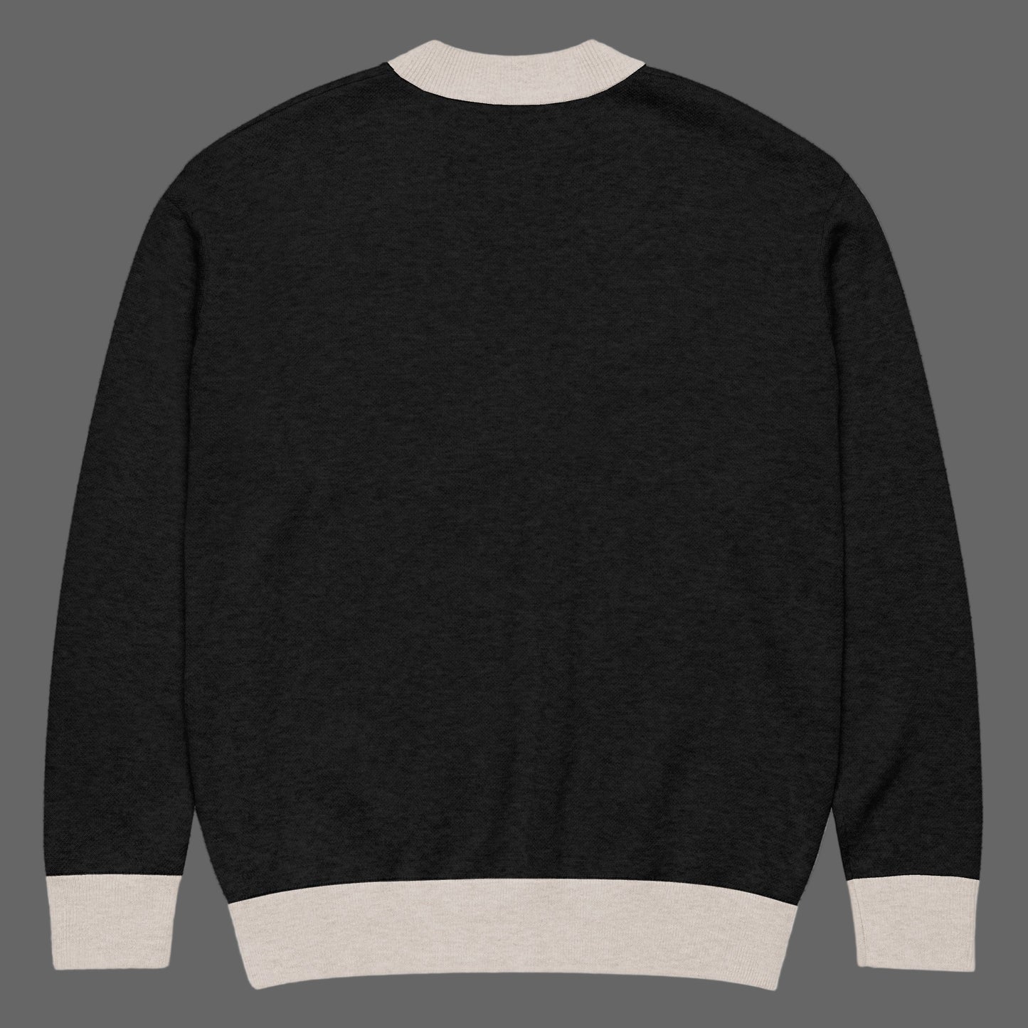 Black sweater with beige trim on a white background