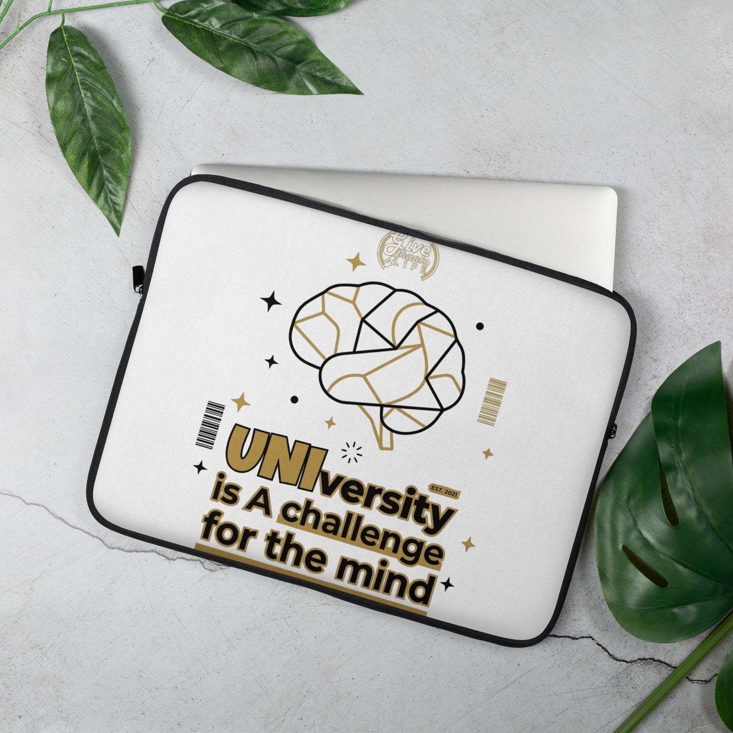 Laptop sleeve with brain design and text on a light gray background with leaves.