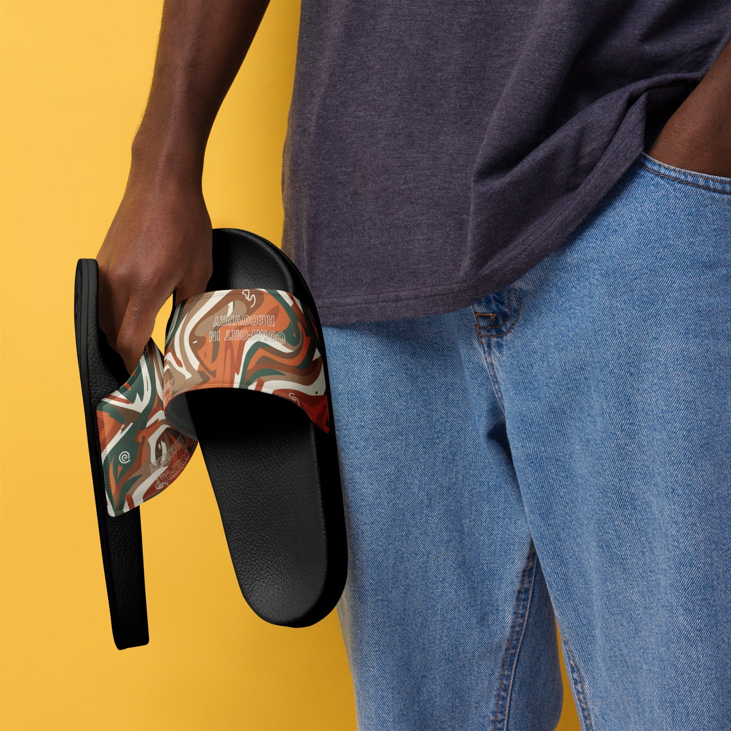 Person holding a colorful sandal with cartoon characters on a yellow background