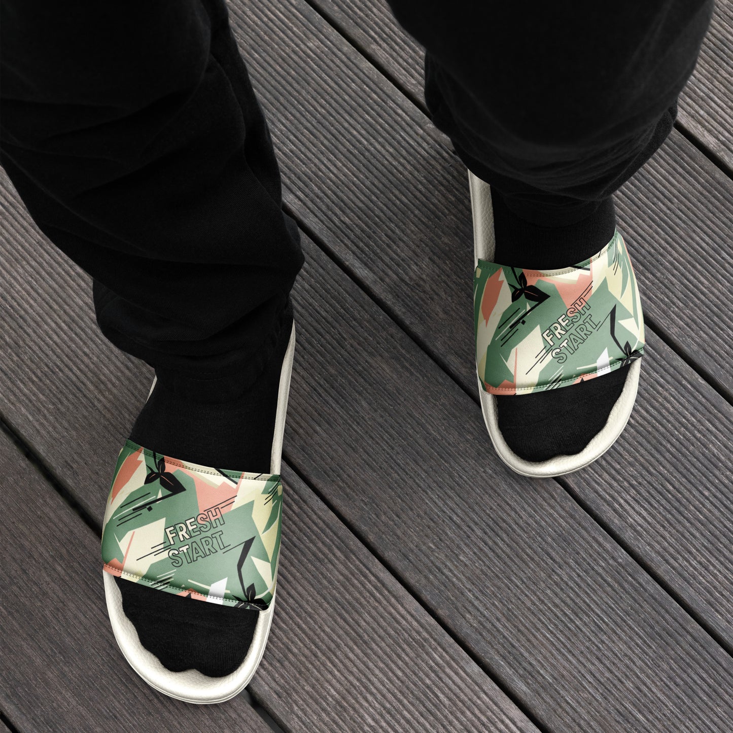 Person wearing green floral sandals on a wooden floor