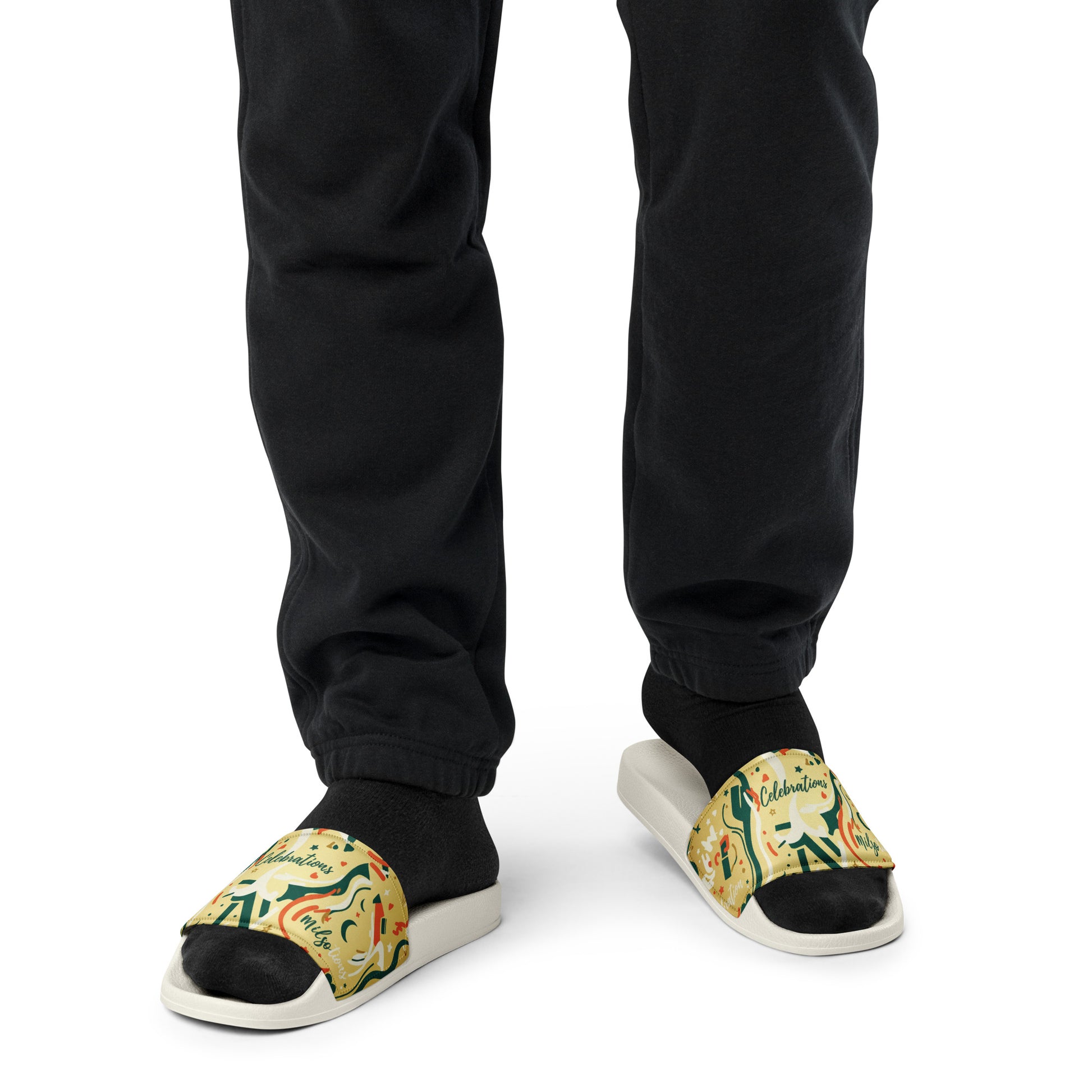 Person wearing black pants and patterned sandals on a white background