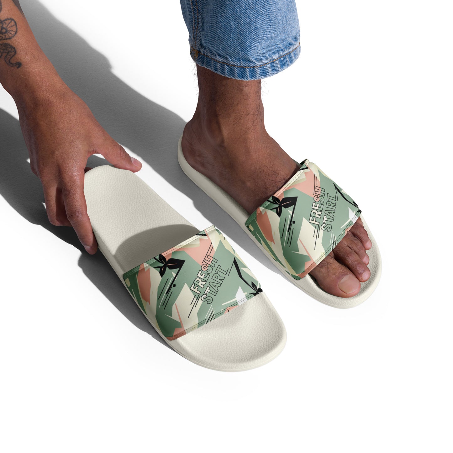 Person wearing white slides with floral design on a white background