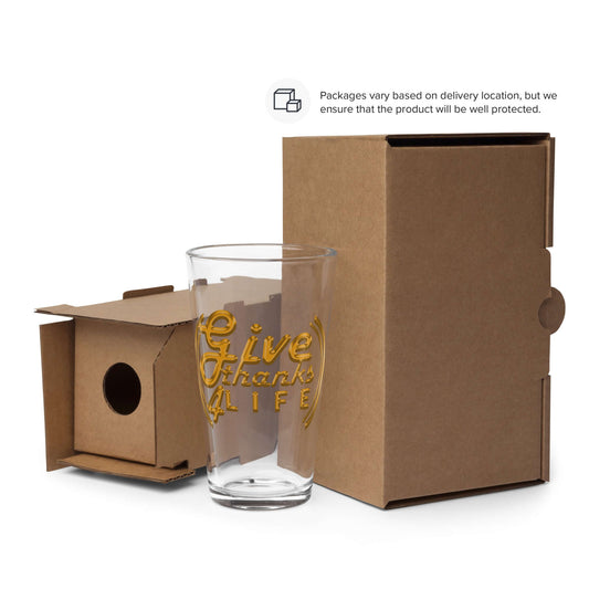 Clear glass with gold text 'Live Life' in front of a cardboard box on a white background