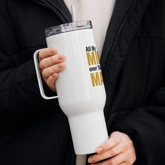 White tumbler with text held by a person wearing a black coat