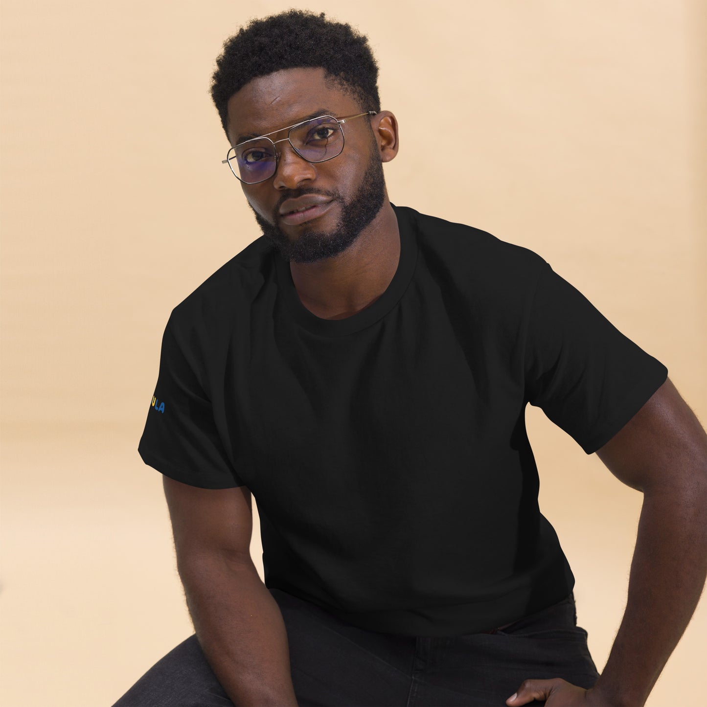 Man wearing a black t-shirt against a beige background