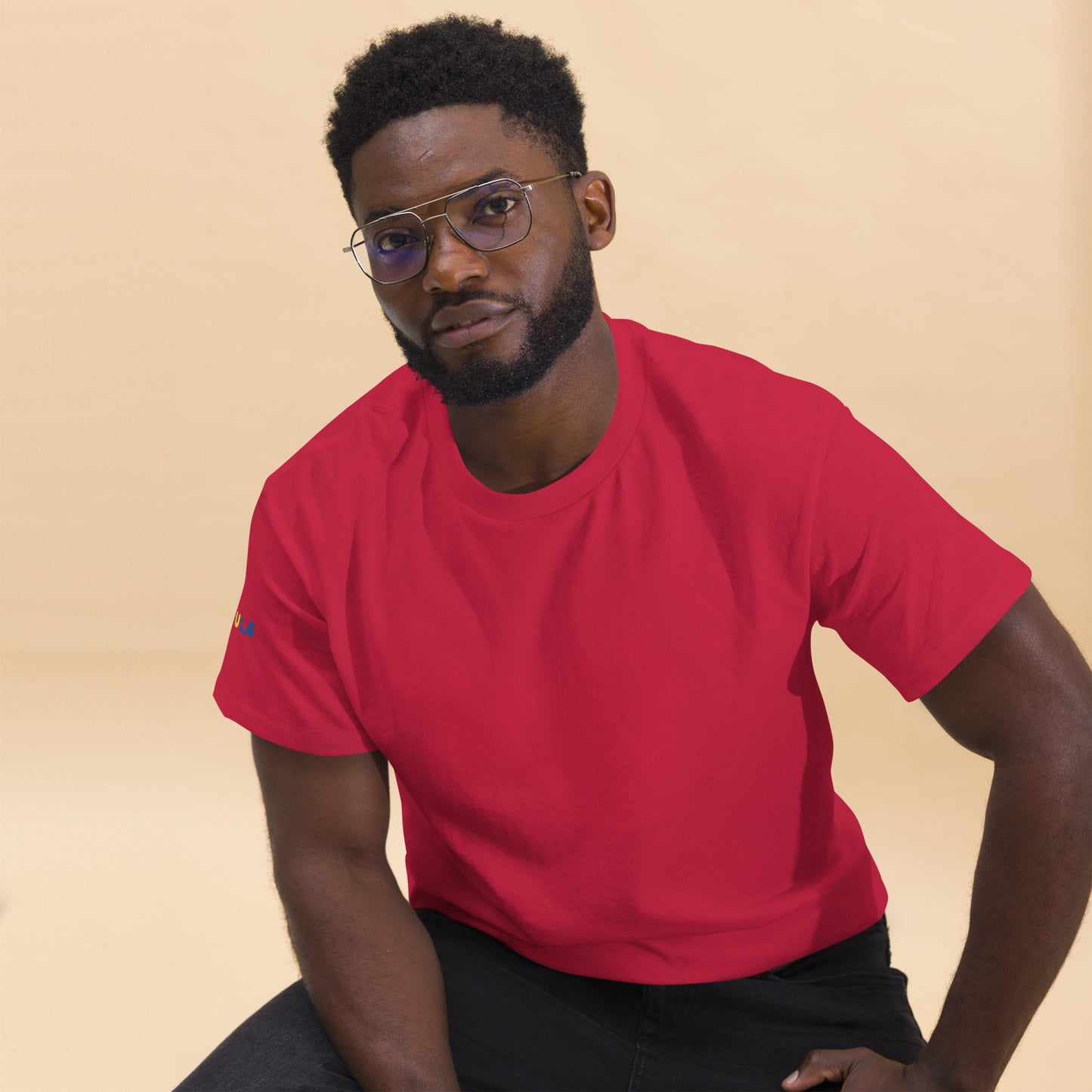 Man wearing a red t-shirt against a beige background