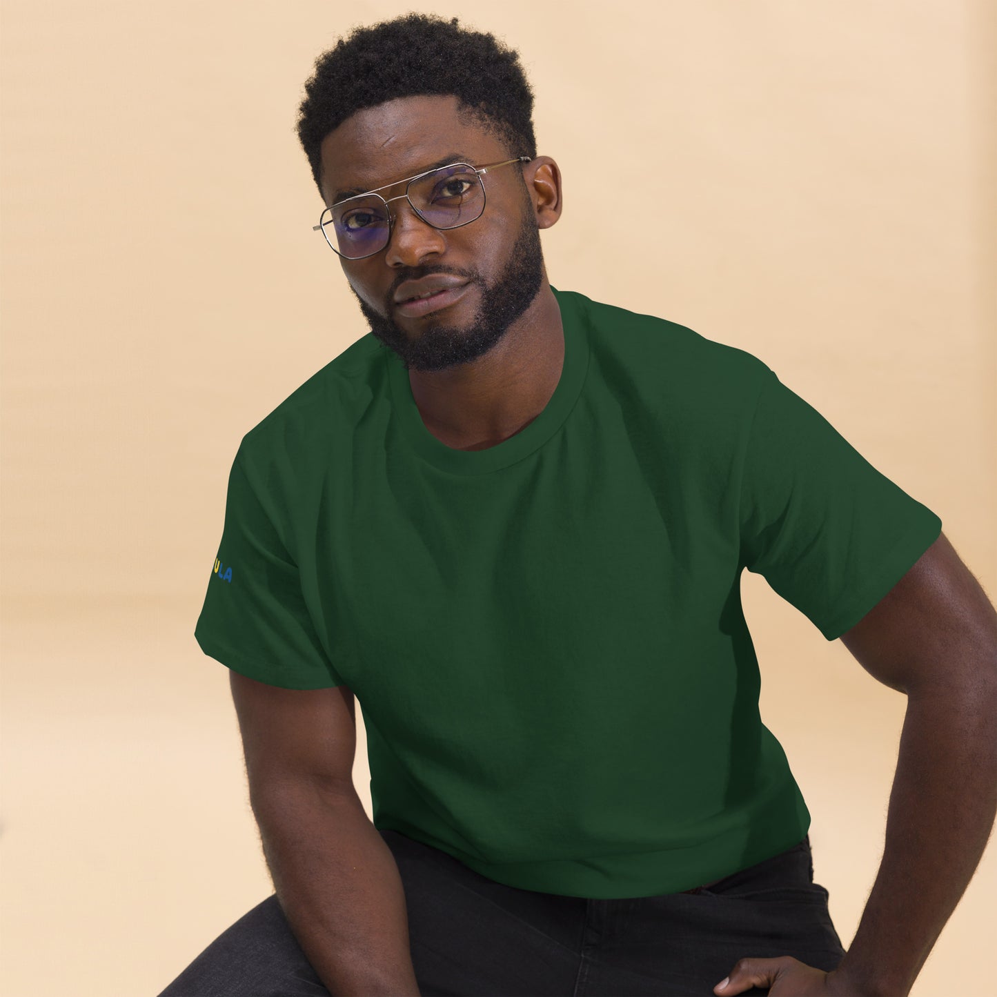 Man wearing a green t-shirt against a beige background